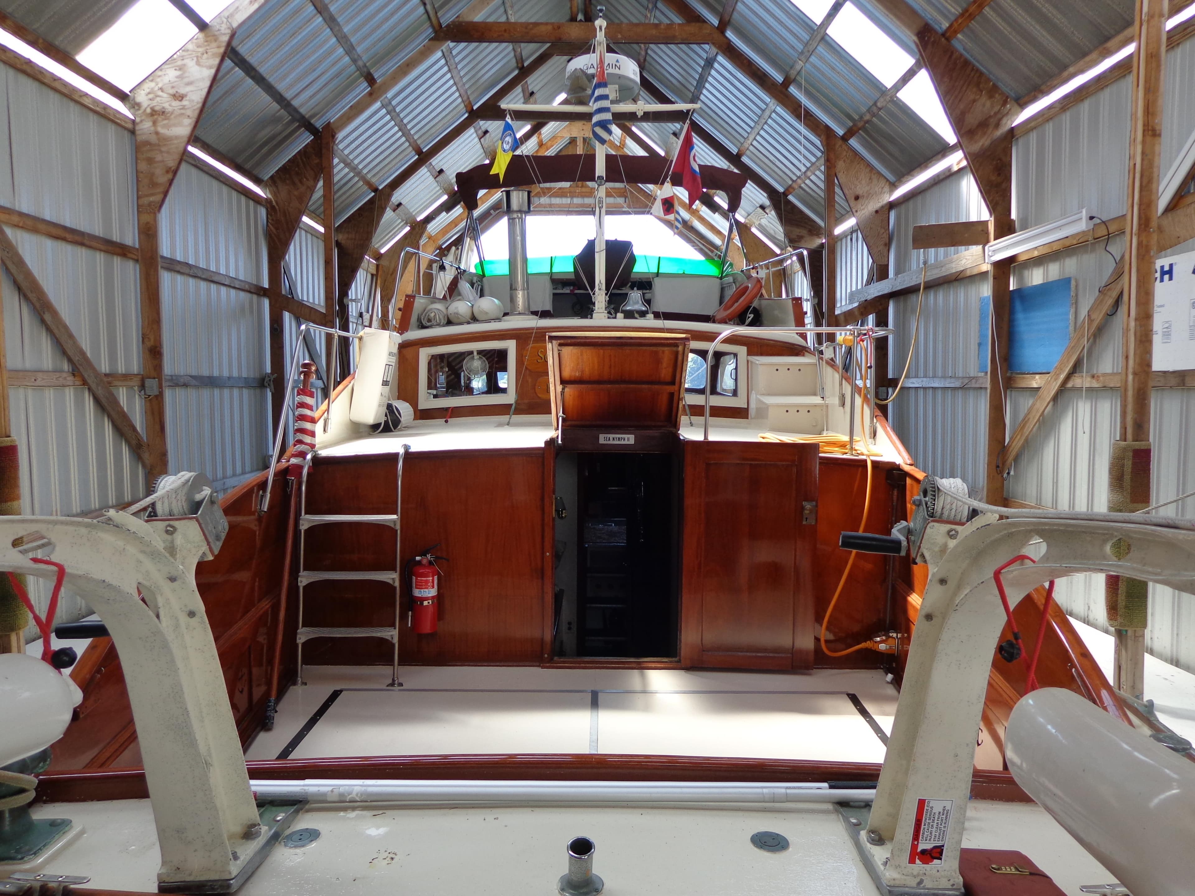 1946 Monk Flybridge Sedan in a boat shed, rear view.