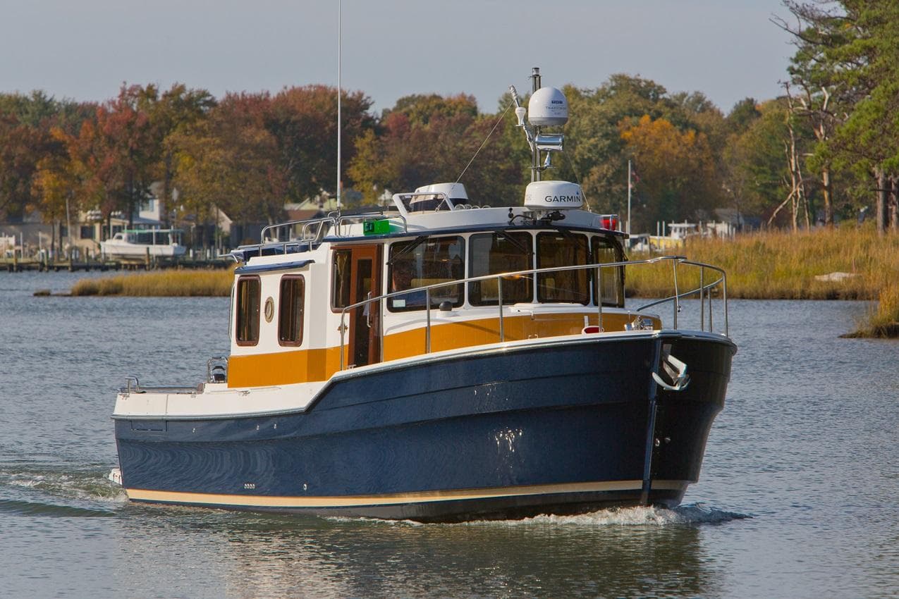 2024 Ranger Tugs R-31 Sedan Luxury Edition cruising on a calm river.