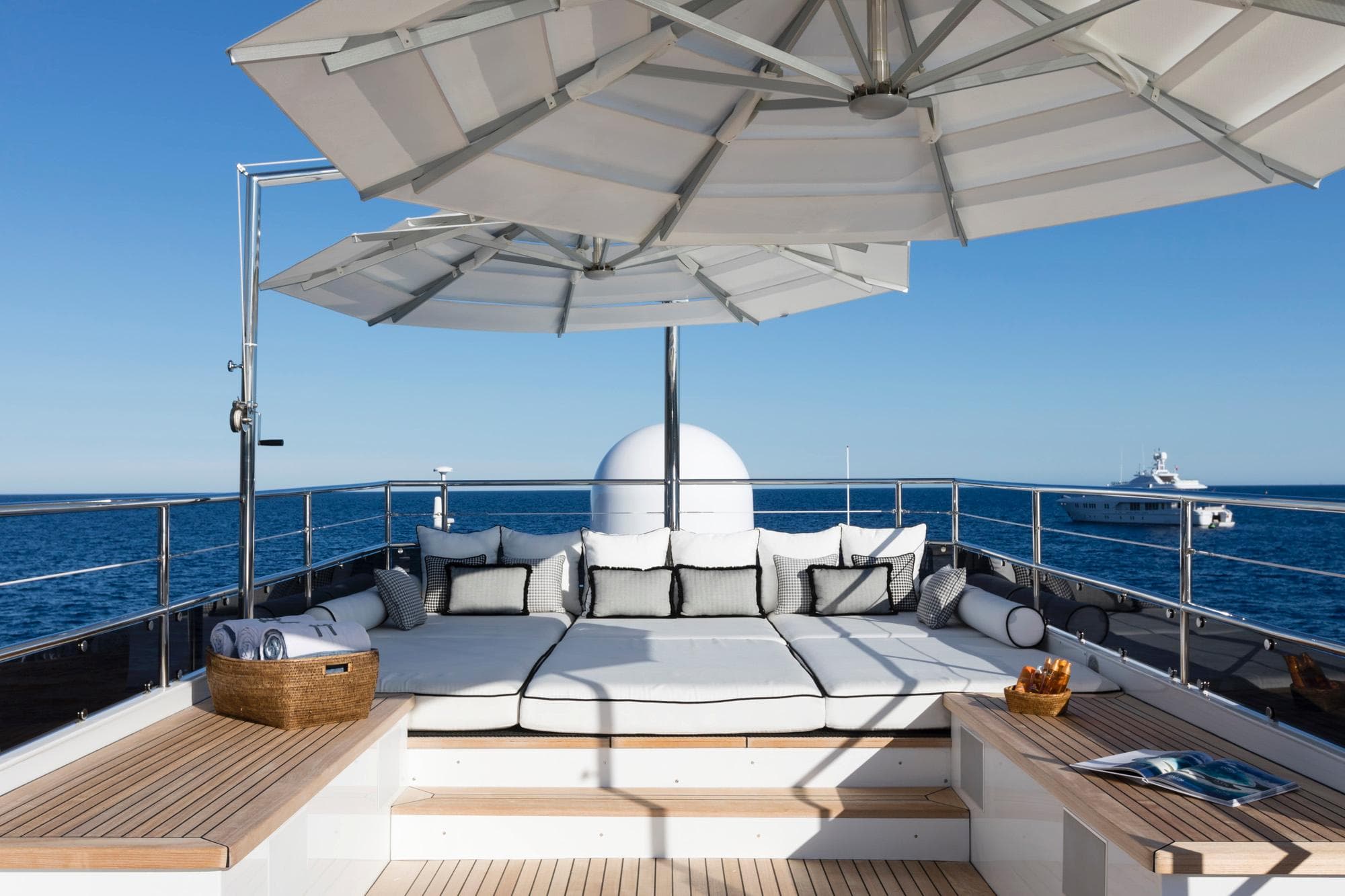Luxurious 1982 Feadship Custom yacht deck with sun loungers and umbrellas, overlooking the ocean.