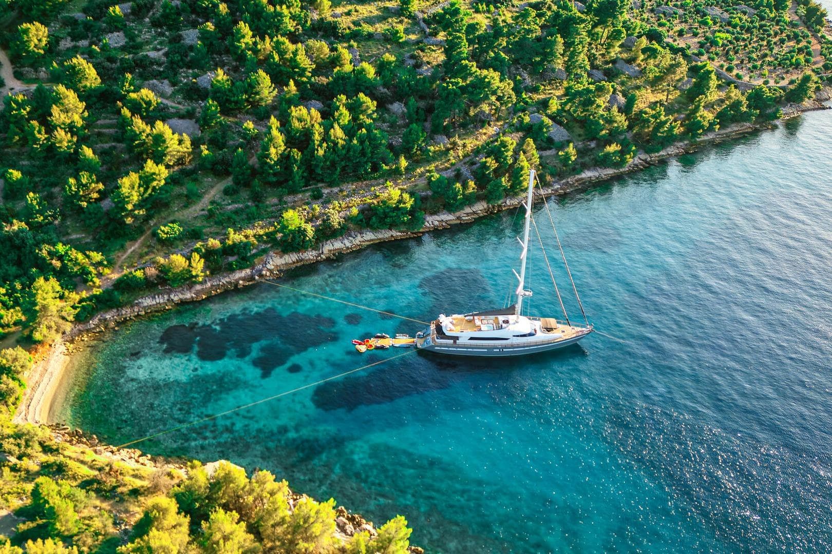 Aerial view of a 2006 Custom Luxury 32m Motor Sailer anchored in a serene bay.