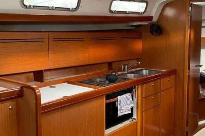 Interior of 2007 Beneteau Cyclades 43.3 yacht kitchen with wooden cabinetry and modern amenities.