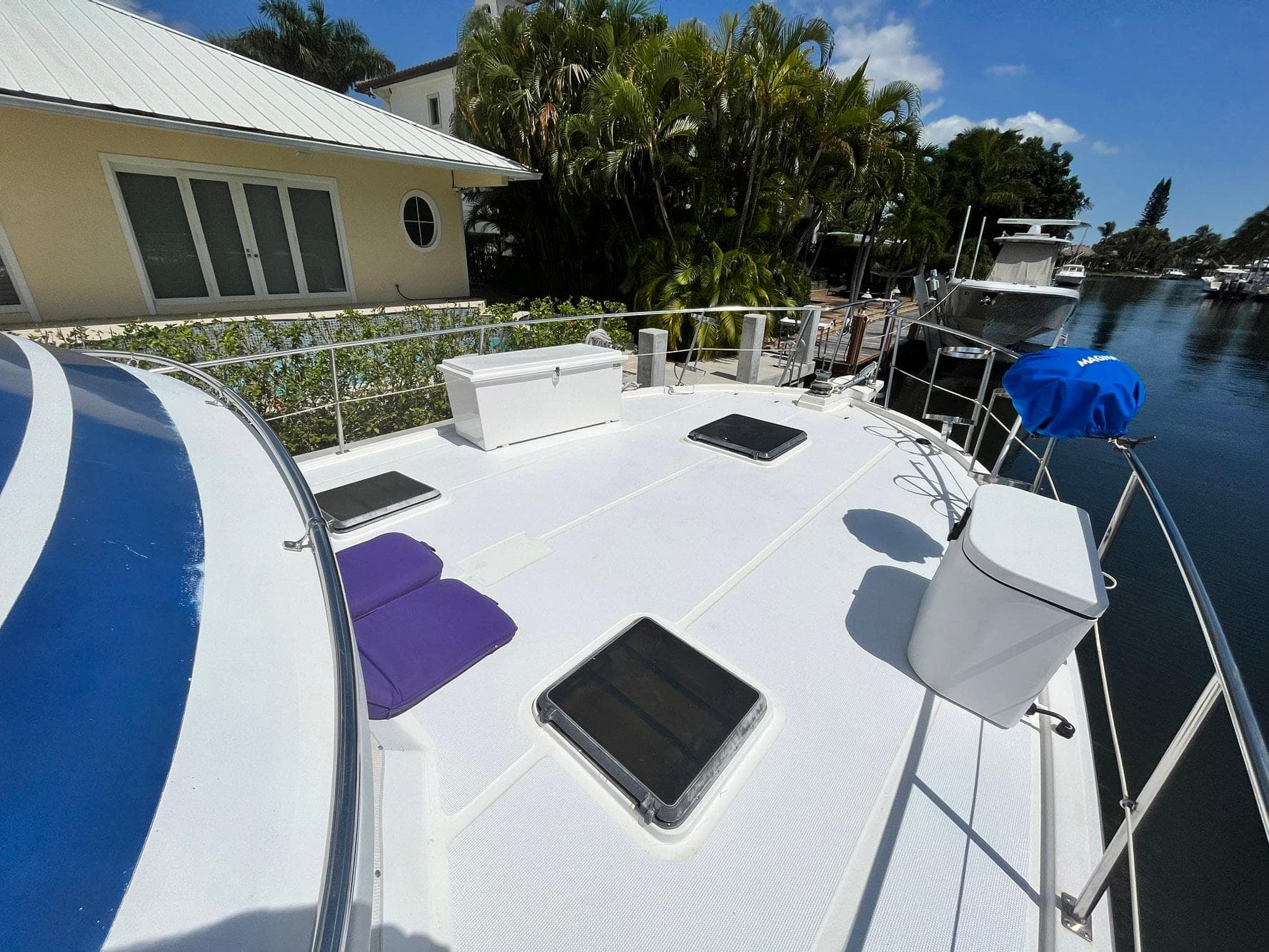 1987 Symbol 44 Sun Deck MK II yacht docked by a waterfront home.