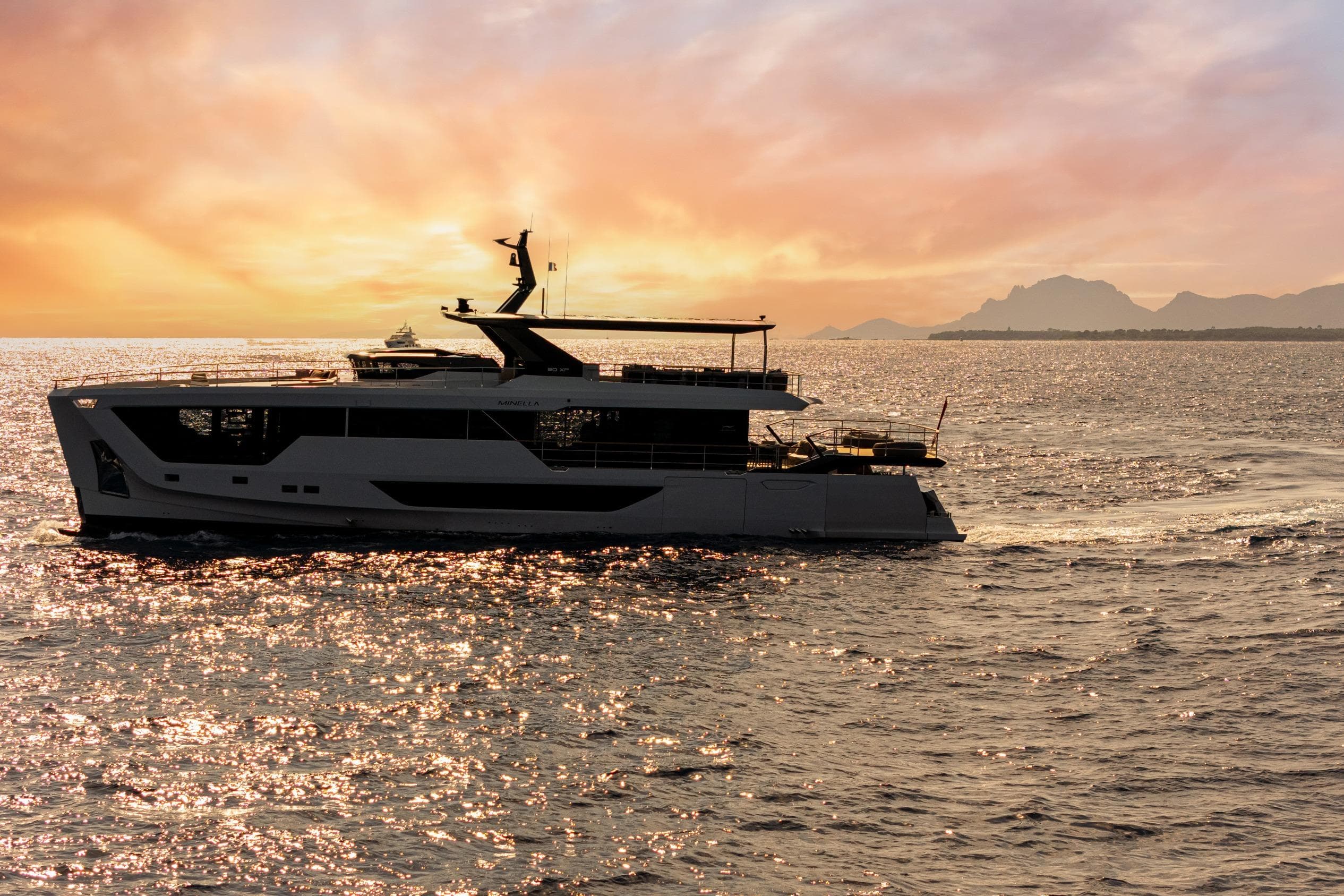 2025 Numarine 30XP yacht cruising at sunset with scenic ocean backdrop.