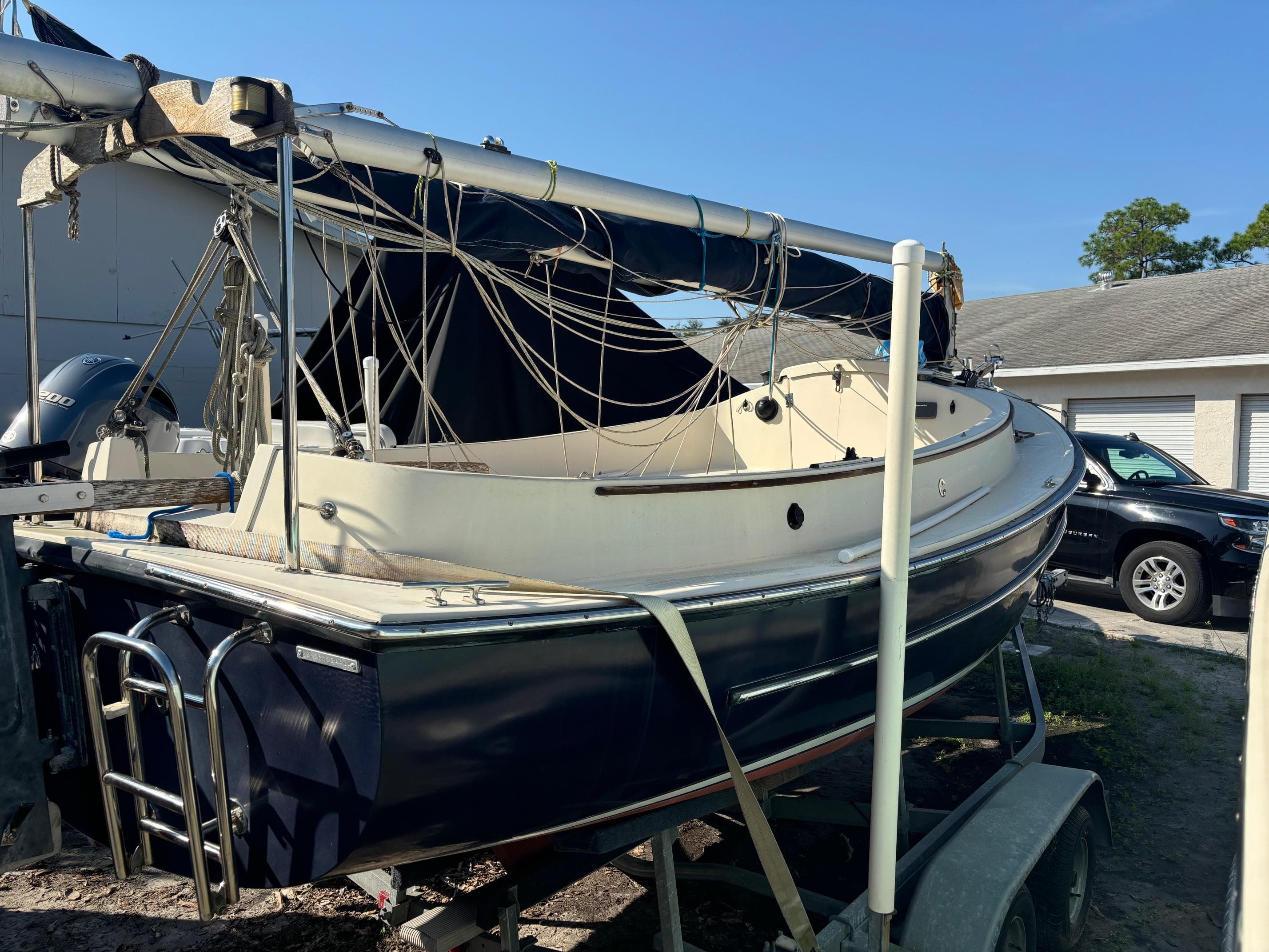 2014 Com-Pac Horizon Day Cat sailboat on trailer, parked outdoors.