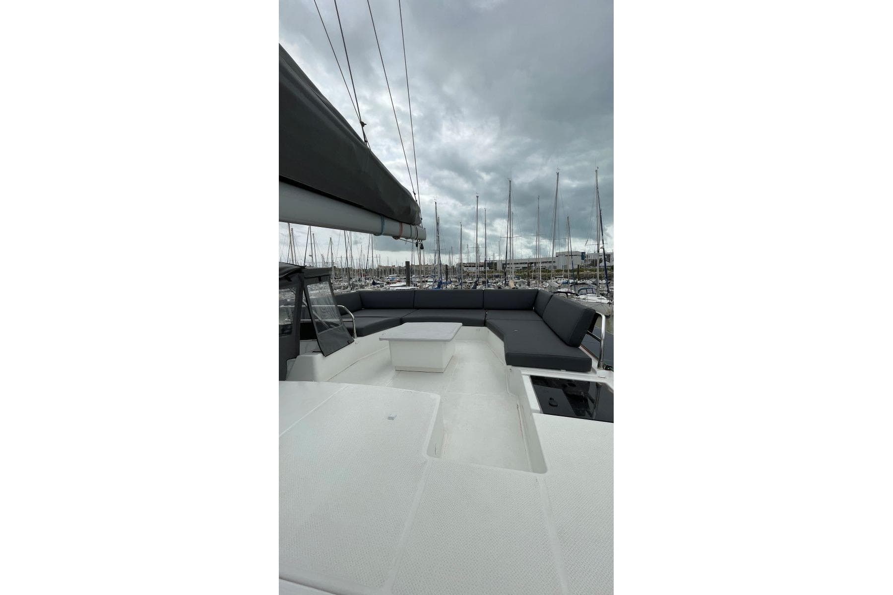 2023 Fountaine Pajot Catamaran Aura 51 deck with seating, under cloudy sky.