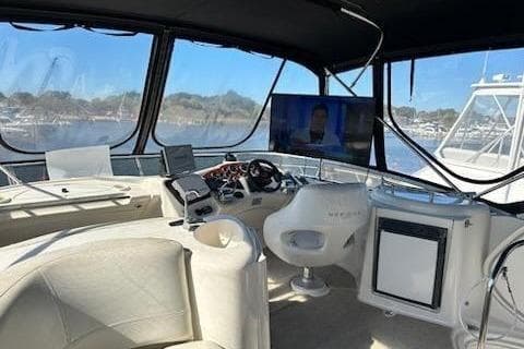 2007 Meridian 391 Sedan yacht interior with helm, seating, and mounted TV.