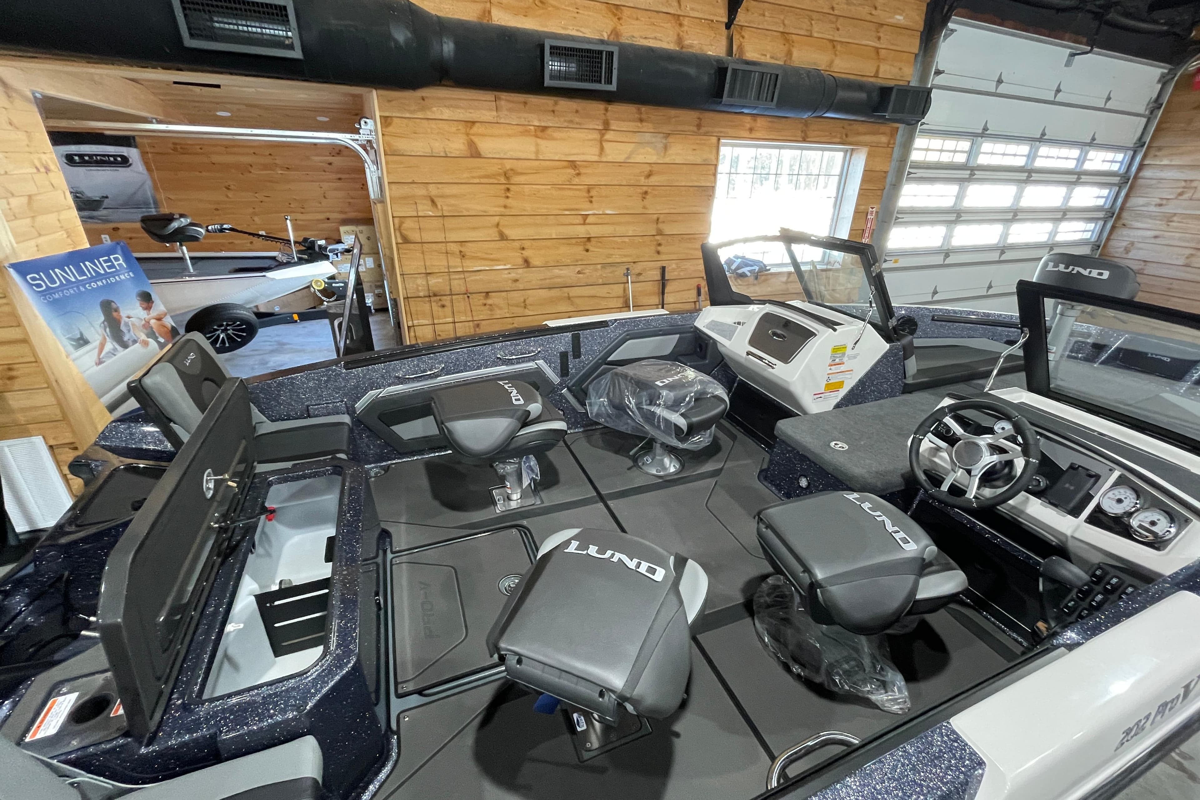 2026 Lund 202 Pro-V GL boat interior with seating and steering wheel in showroom.