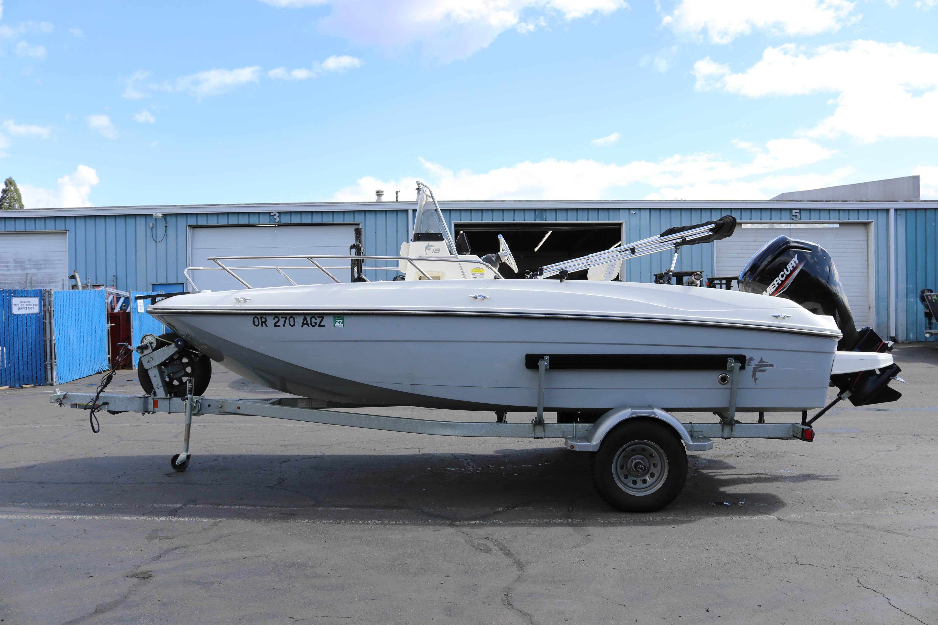 2020 Bayliner Element boat on trailer, parked outdoors near industrial buildings.