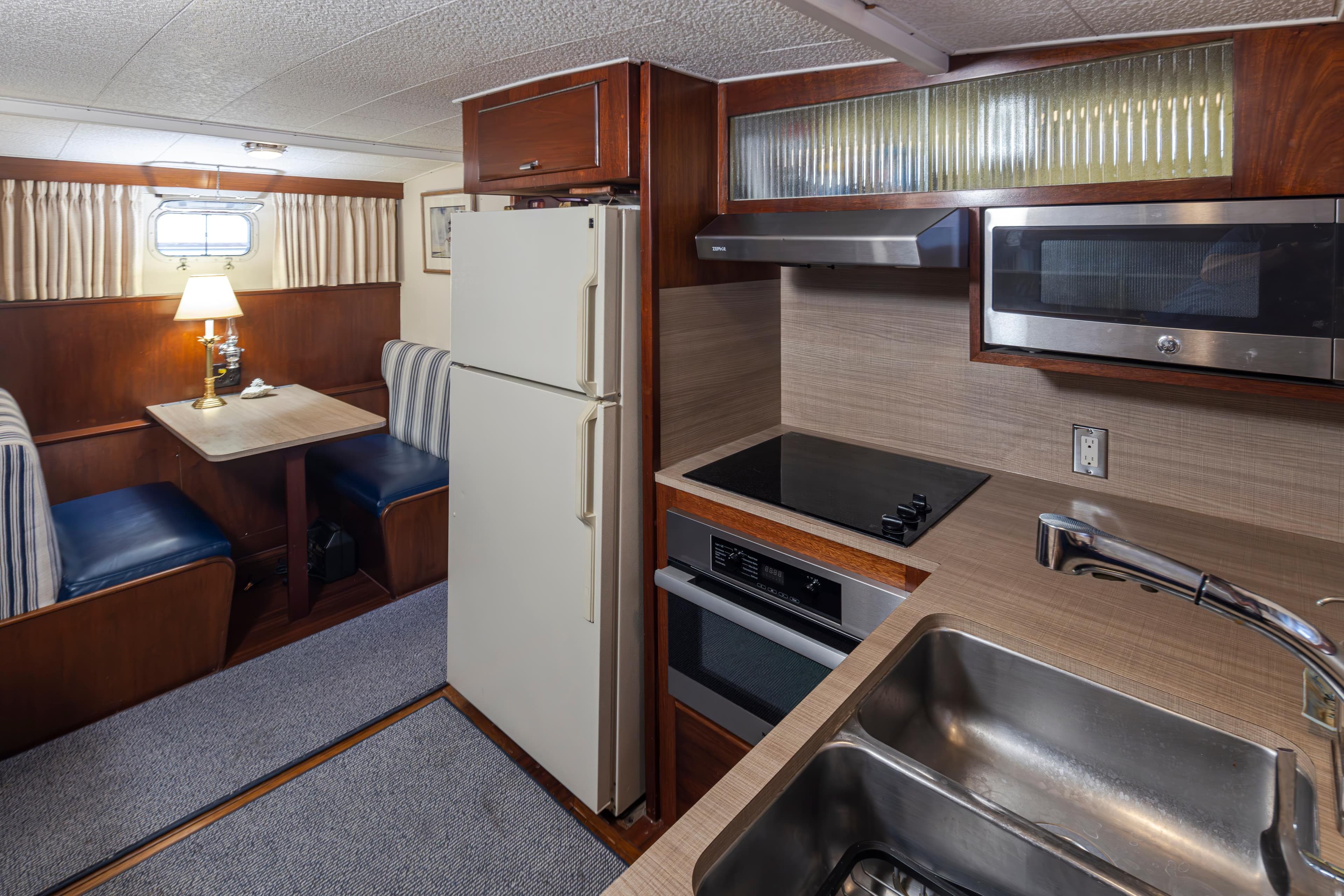Interior of a 1965 Stephens Flushdeck yacht with kitchen and dining area.