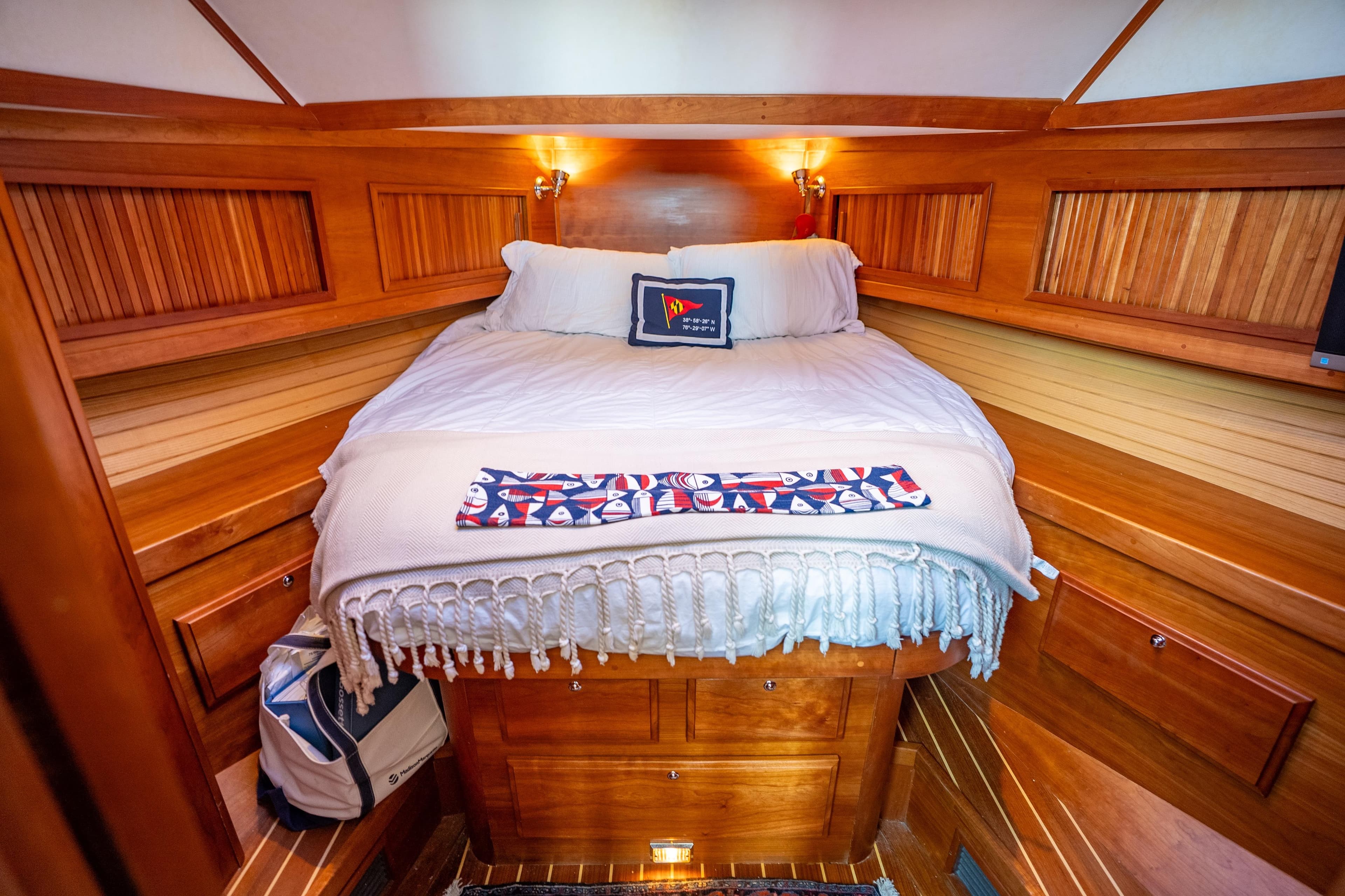 Cozy cabin interior of 2006 Sabreline 36 Fly yacht with wooden finish and comfortable bedding.