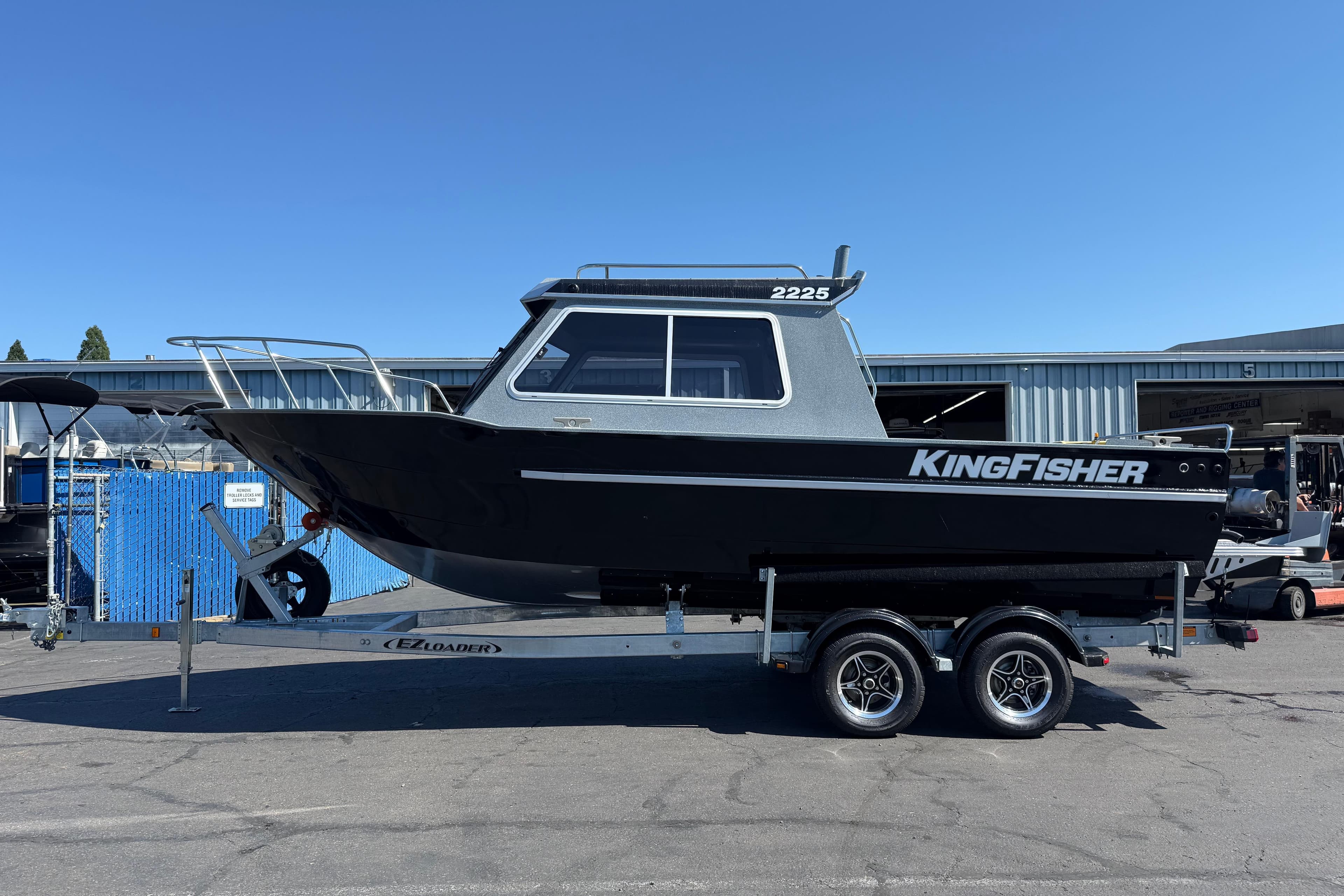 2025 KingFisher 2225 Escape HT boat on trailer, parked outdoors.