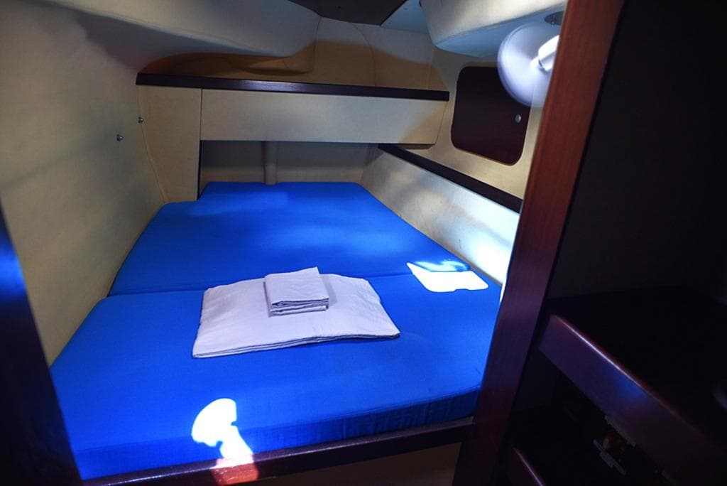 Cozy cabin interior of 1997 Fountaine Pajot Athena 38 with blue bedding.