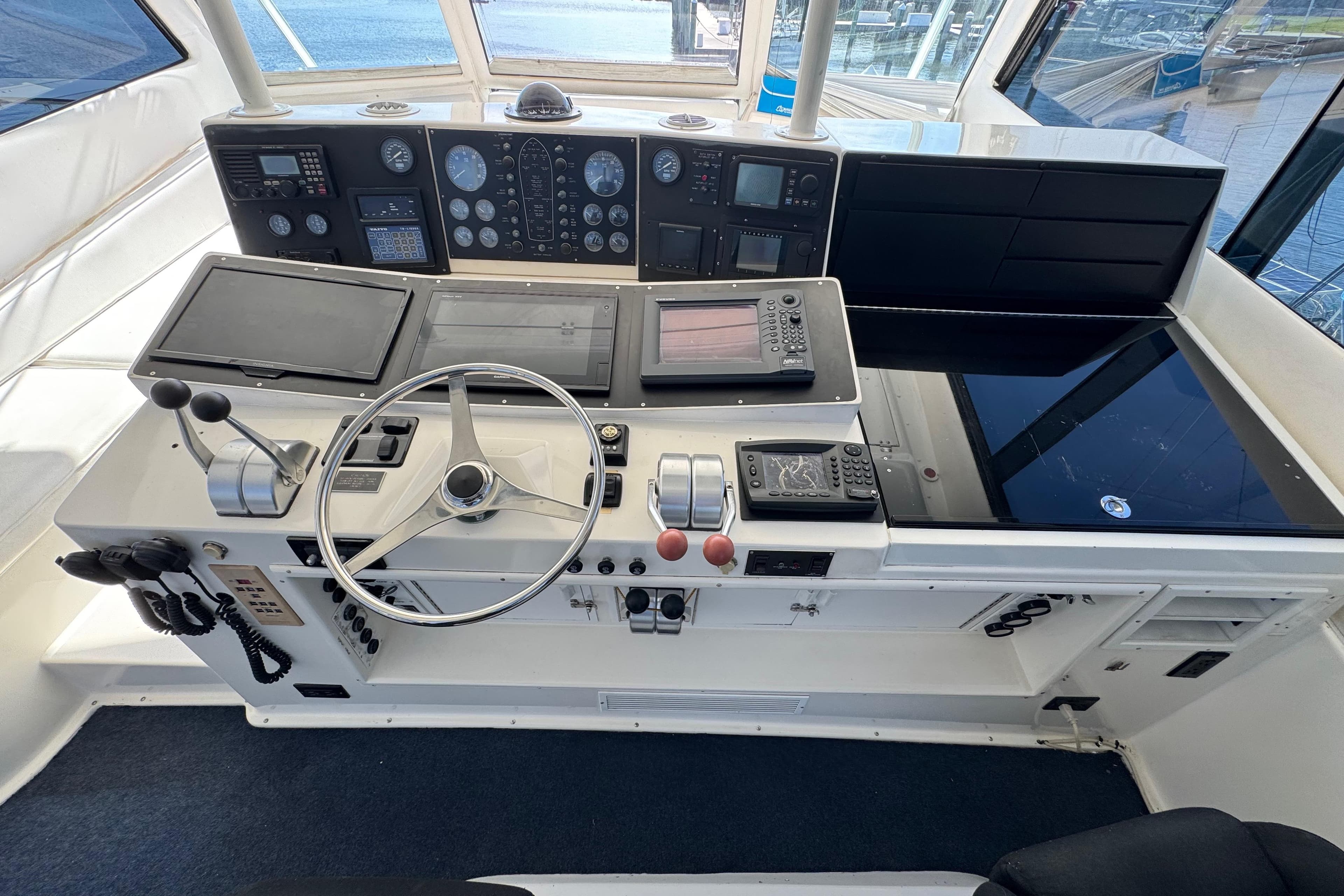 Cockpit of 1995 Viking 58 Convertible yacht with steering wheel and navigation instruments.