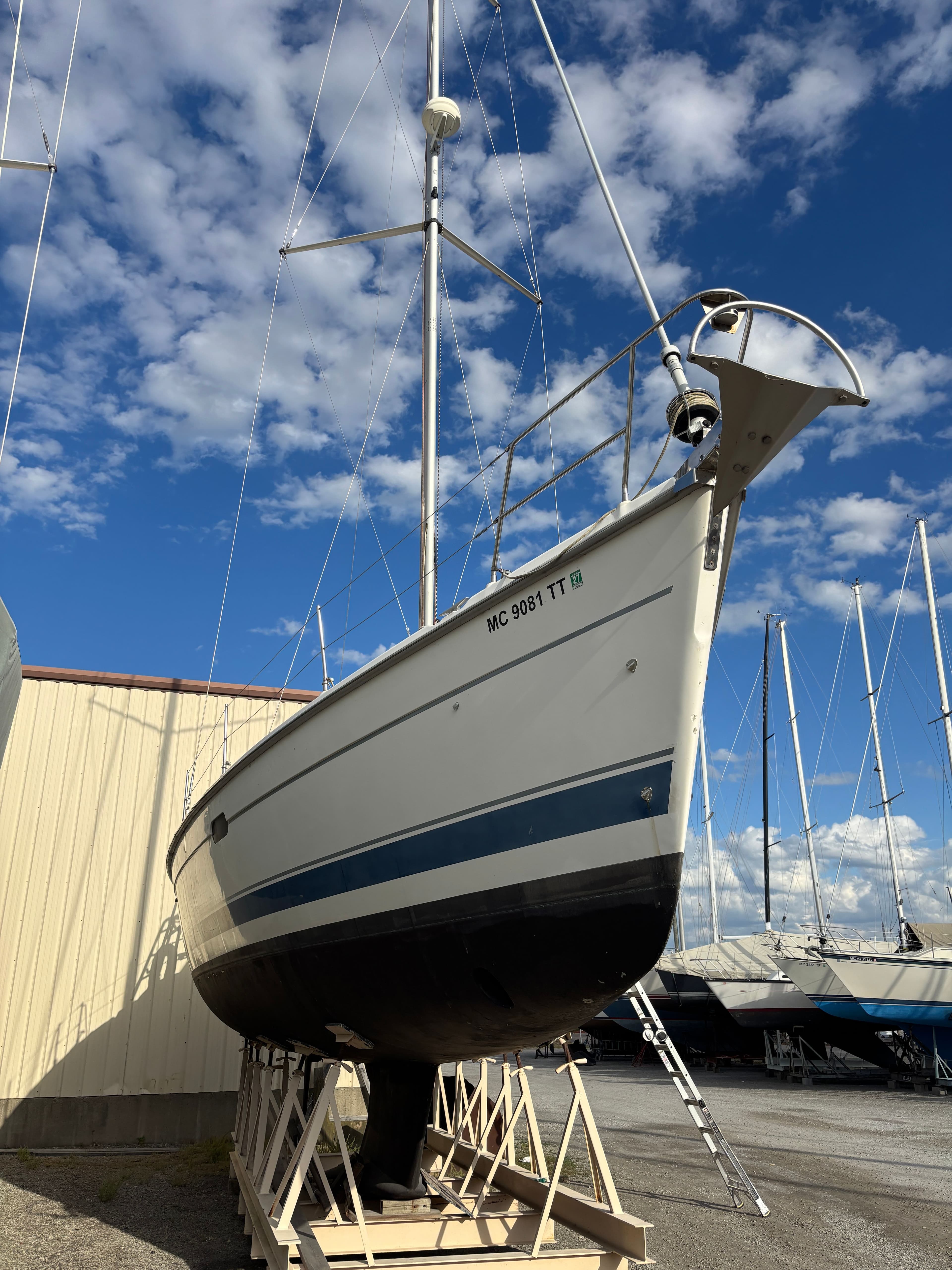 2001 Hunter 460 sailboat on dry dock under a blue sky with scattered clouds.
