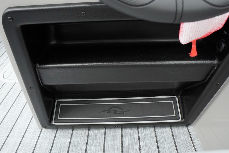 Storage compartment in 2026 SunCatcher Select 322SL boat, featuring sleek black design and striped flooring.
