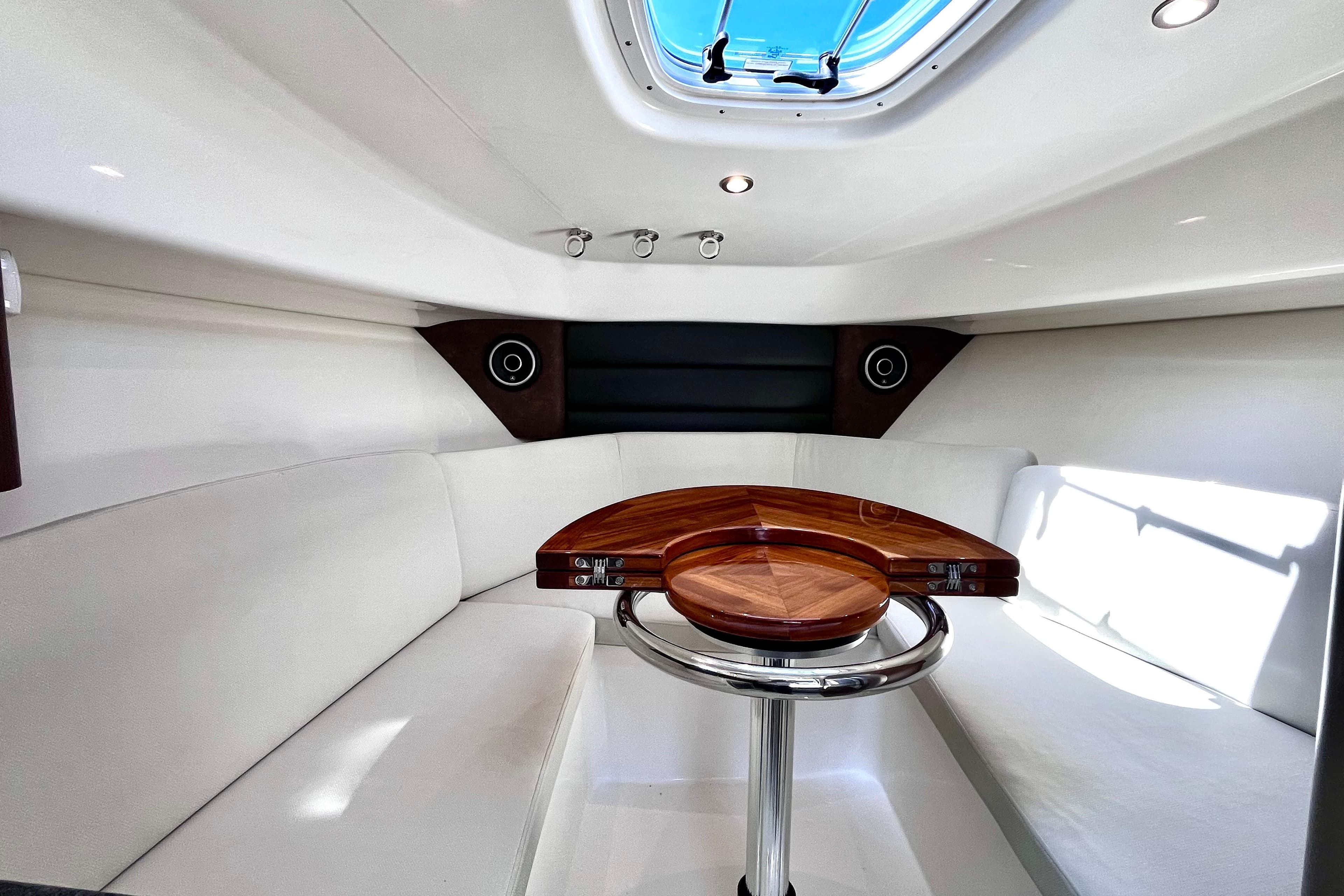 Luxurious interior of 2023 Boston Whaler 285 Conquest boat with elegant seating and wooden table.
