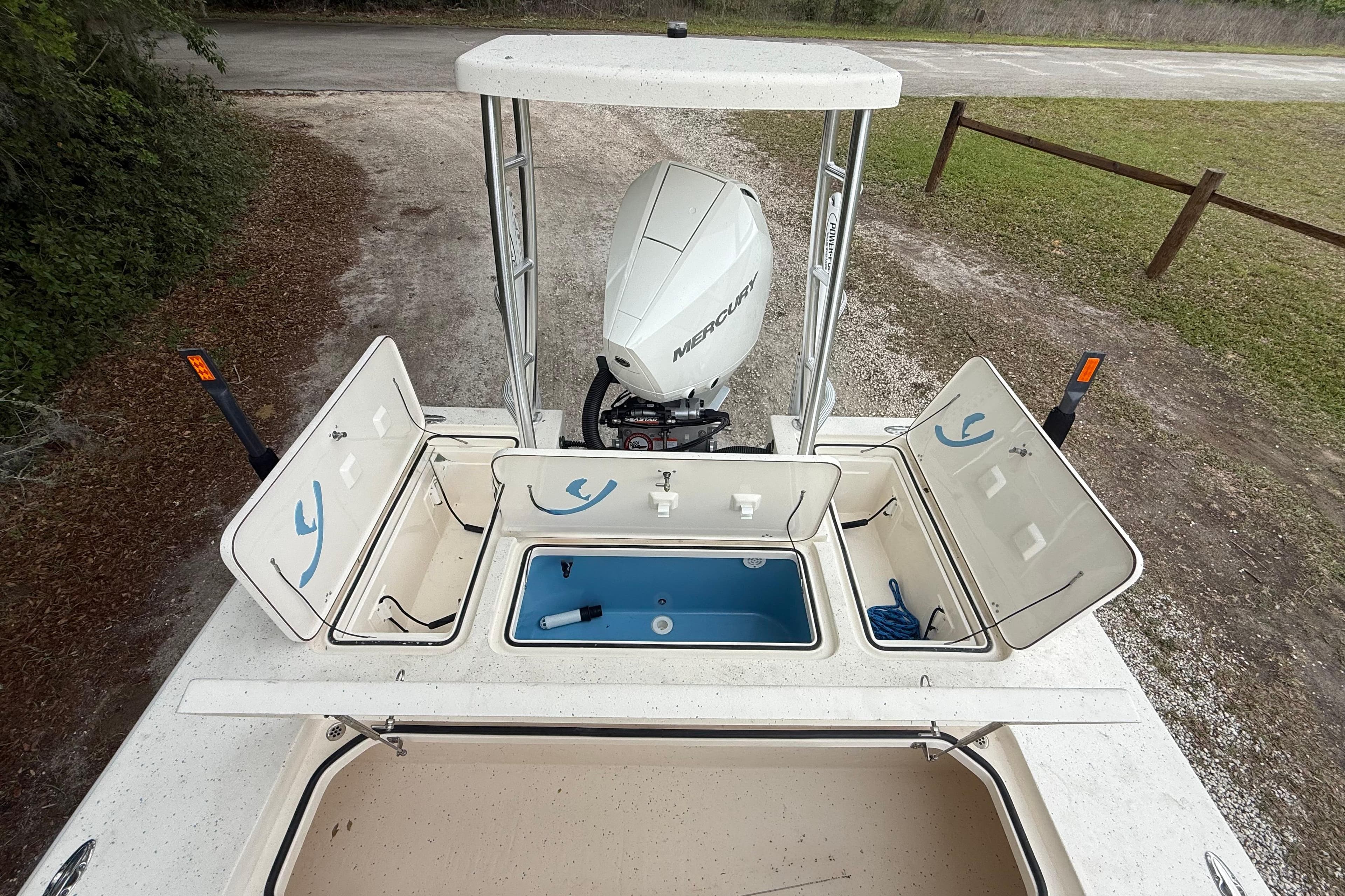 2021 Young Boats Gulf Shores 24 with open storage compartments and Mercury outboard motor.