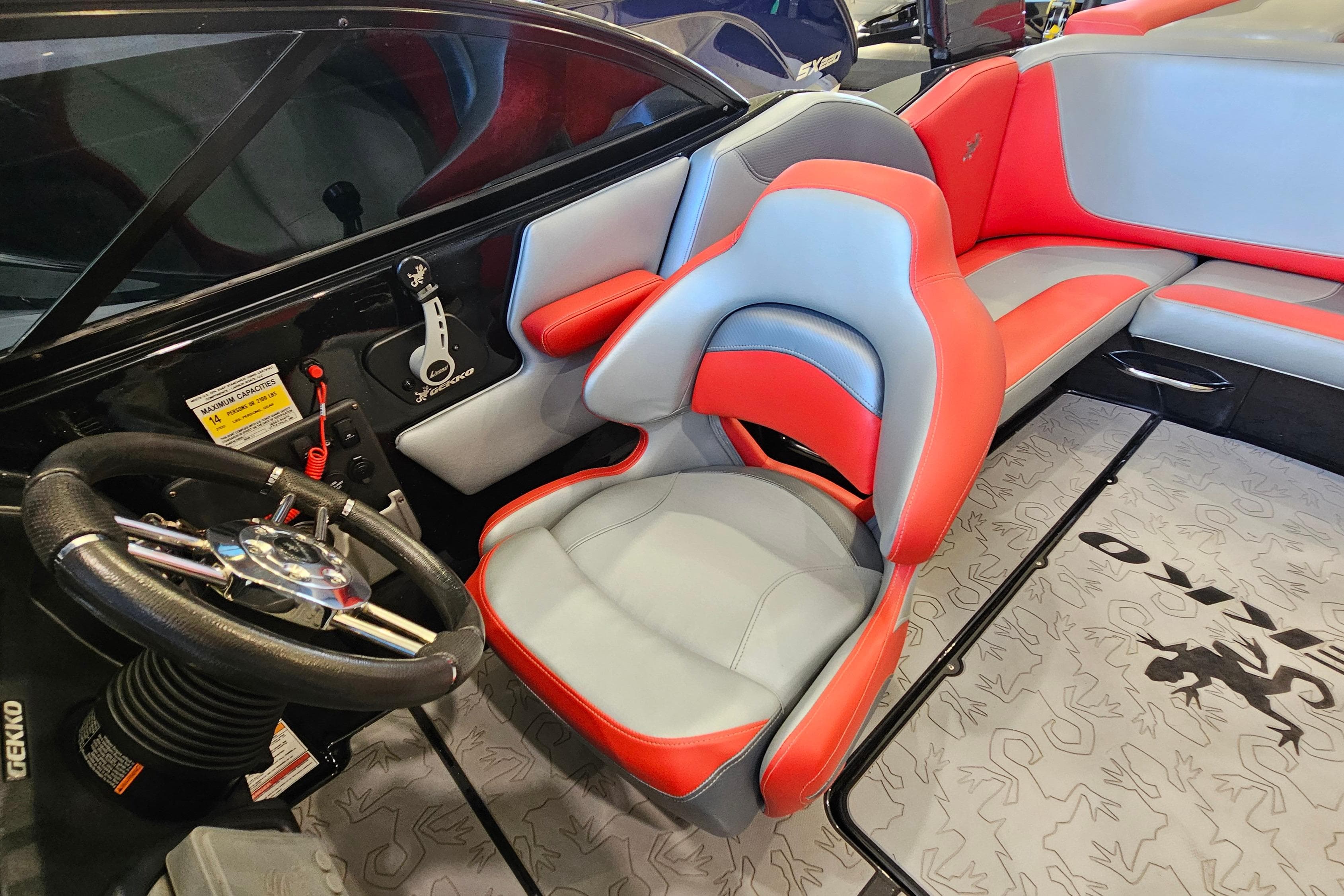 Interior of a 2017 Gekko Revo 7.1 boat with red and gray seating.