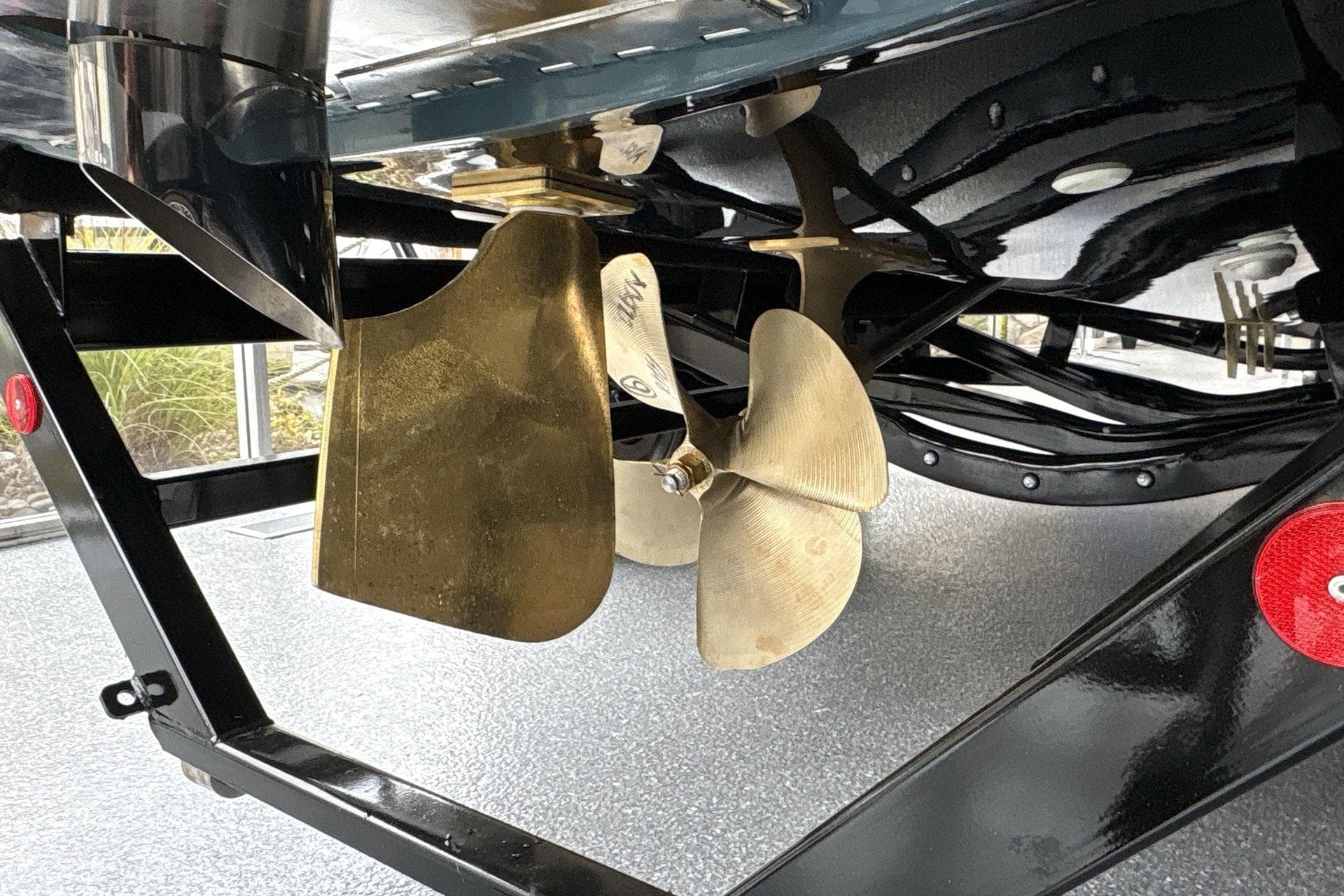 Propeller and rudder of 2026 MasterCraft NXT22 boat on trailer.