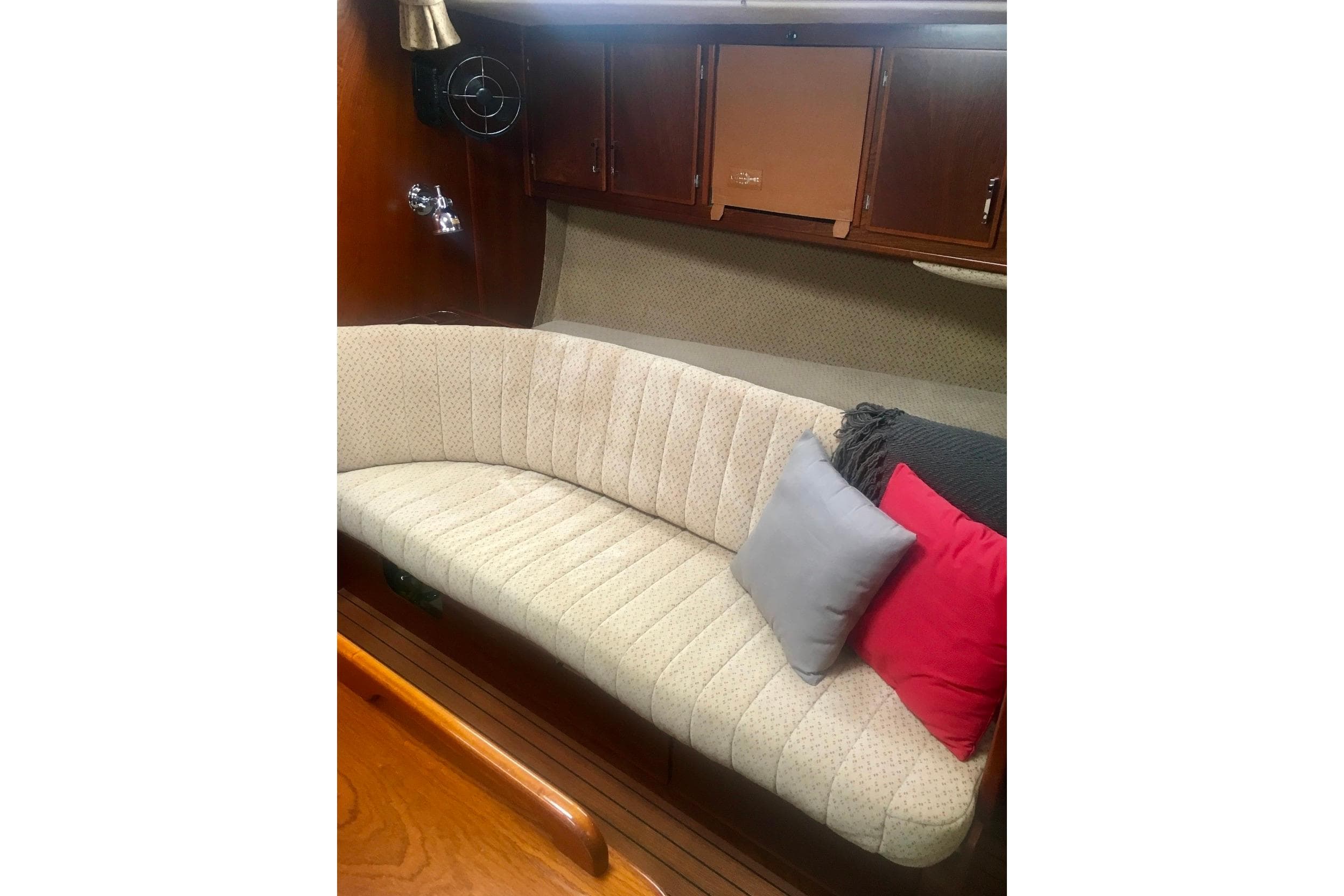 Interior of 1993 Amel Santorin Sloop with cushioned seating and colorful pillows.
