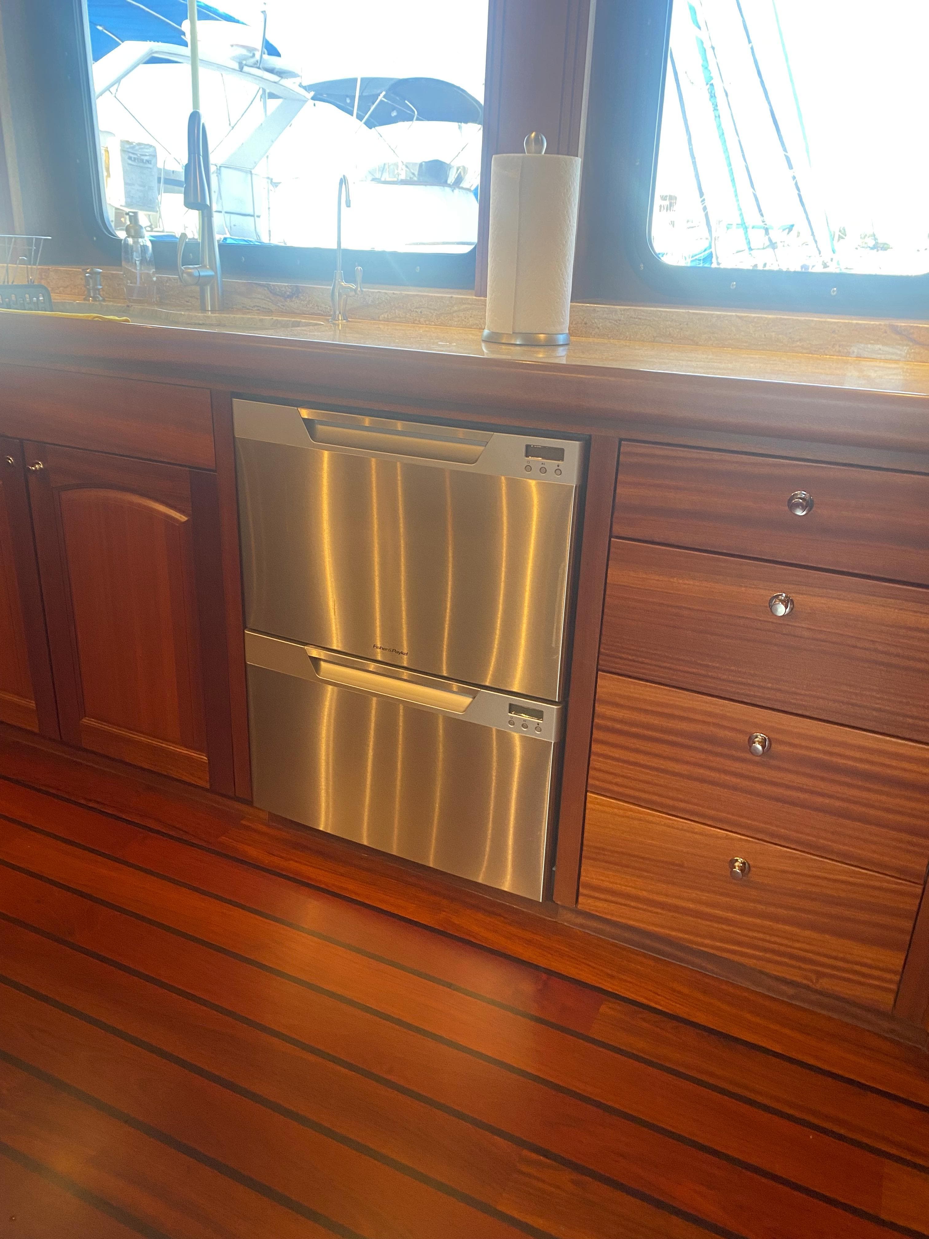 Luxurious Allseas Expedition 2018 yacht kitchen with stainless steel appliances and wooden cabinetry.