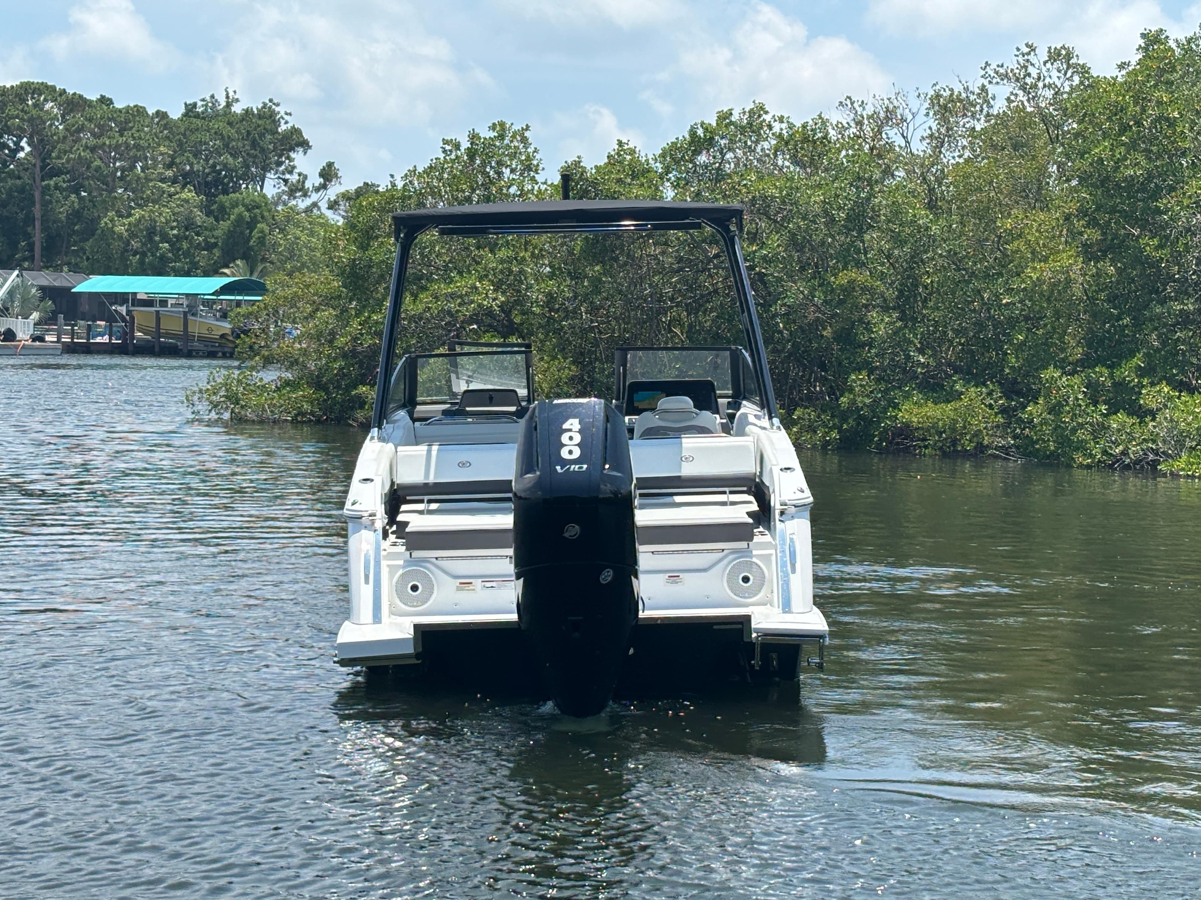 2024 Cobalt R8 Outboard boat on a calm river with lush greenery.