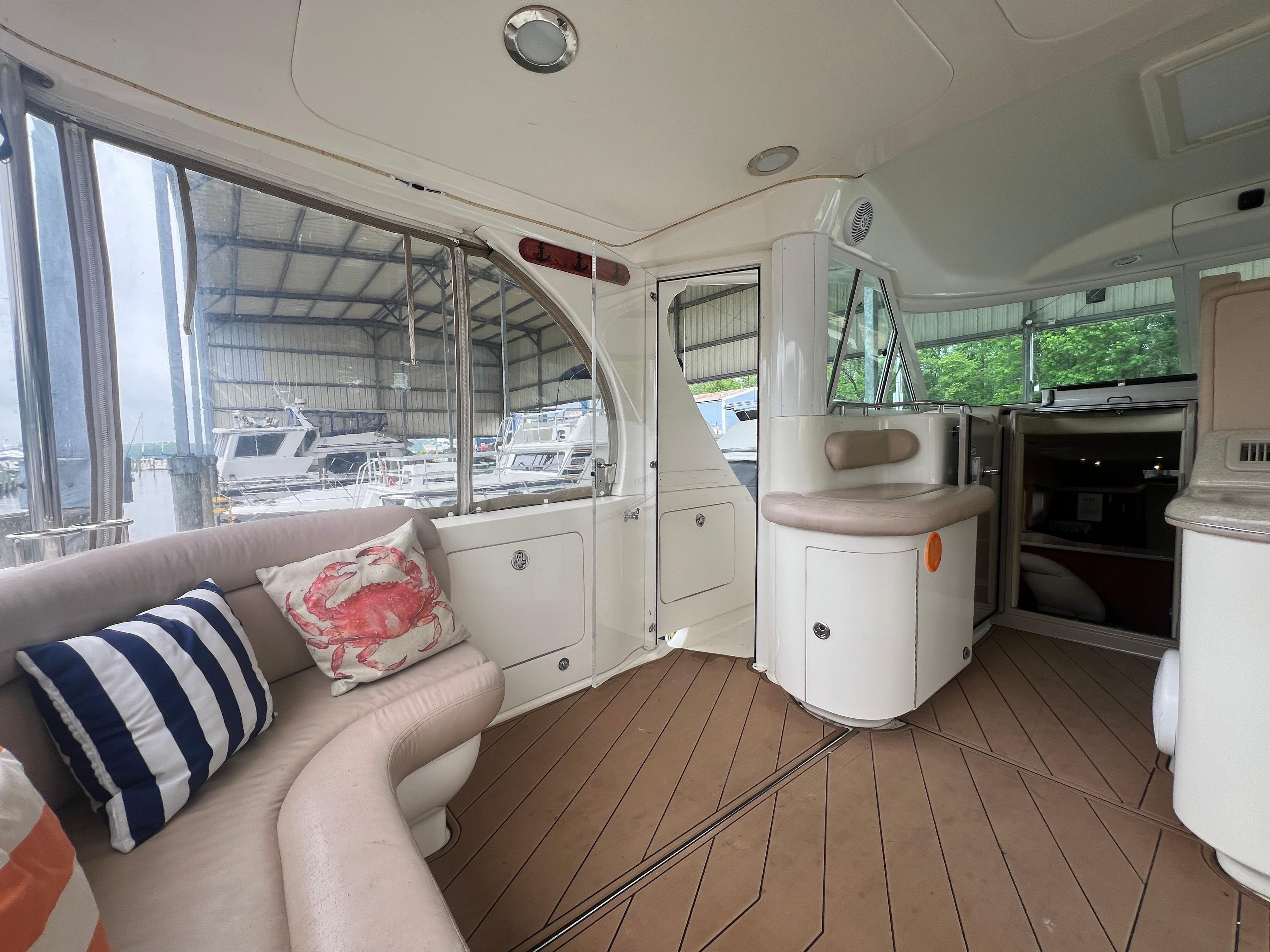 Interior of 2004 Sea Ray 480 Motor Yacht with plush seating and nautical-themed pillows.