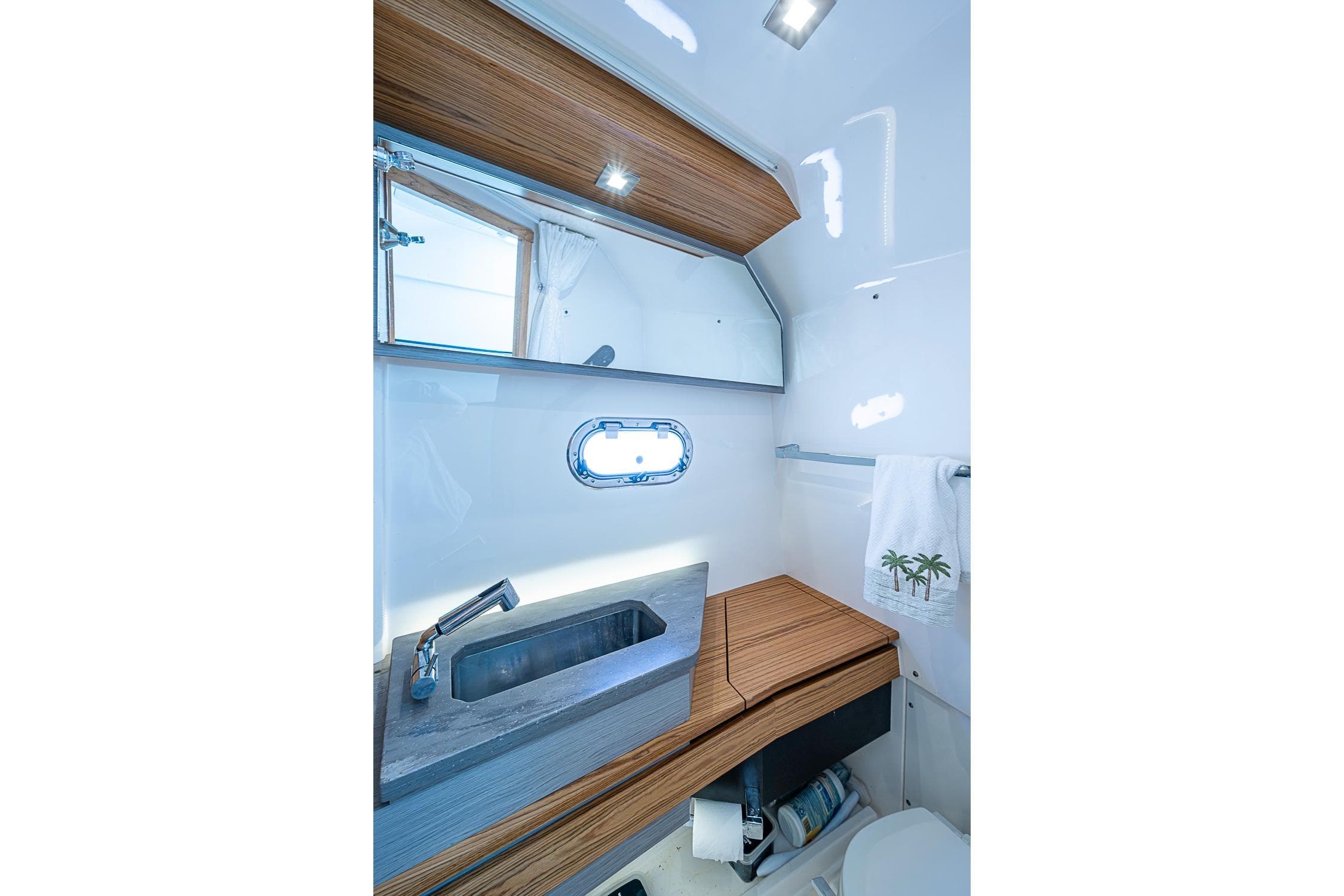 Luxurious 2023 Tiara Sport 34 LS yacht bathroom with modern sink and wooden accents.