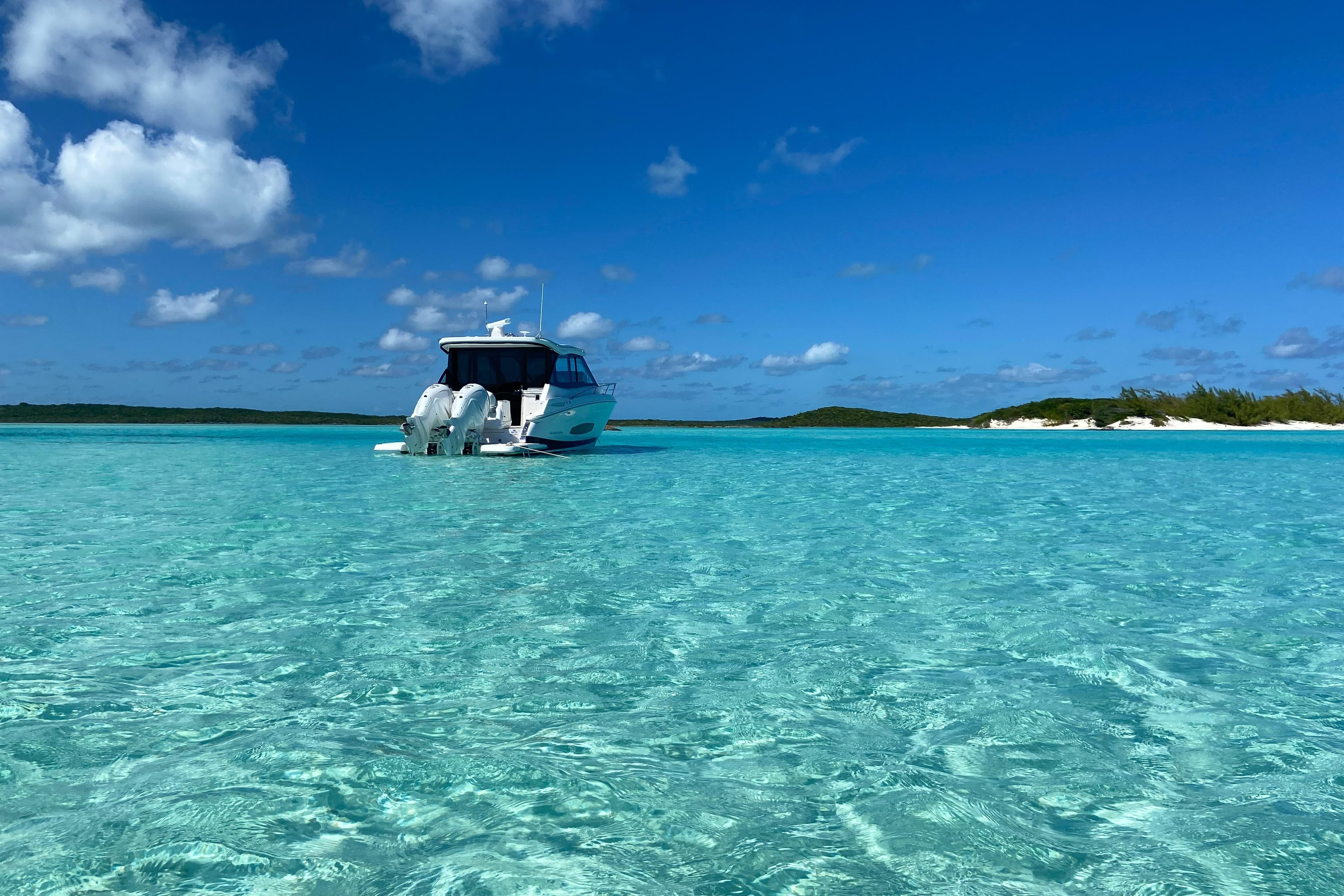 2023 Regal 36 XO boat anchored in clear turquoise waters under a bright blue sky.