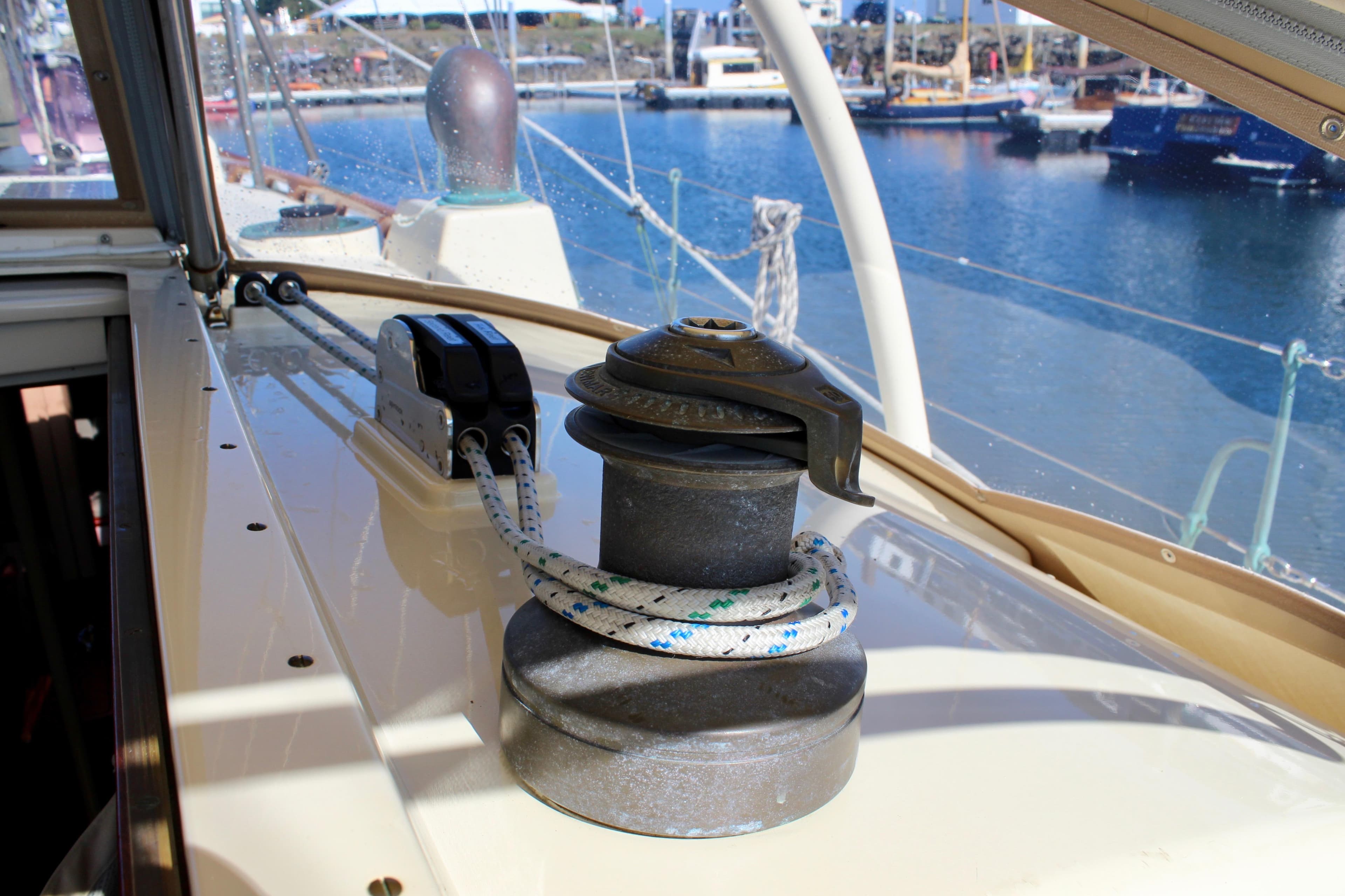 Winch and rope on 2012 Custom Gartside Jespersen 40 sailboat deck, marina background.