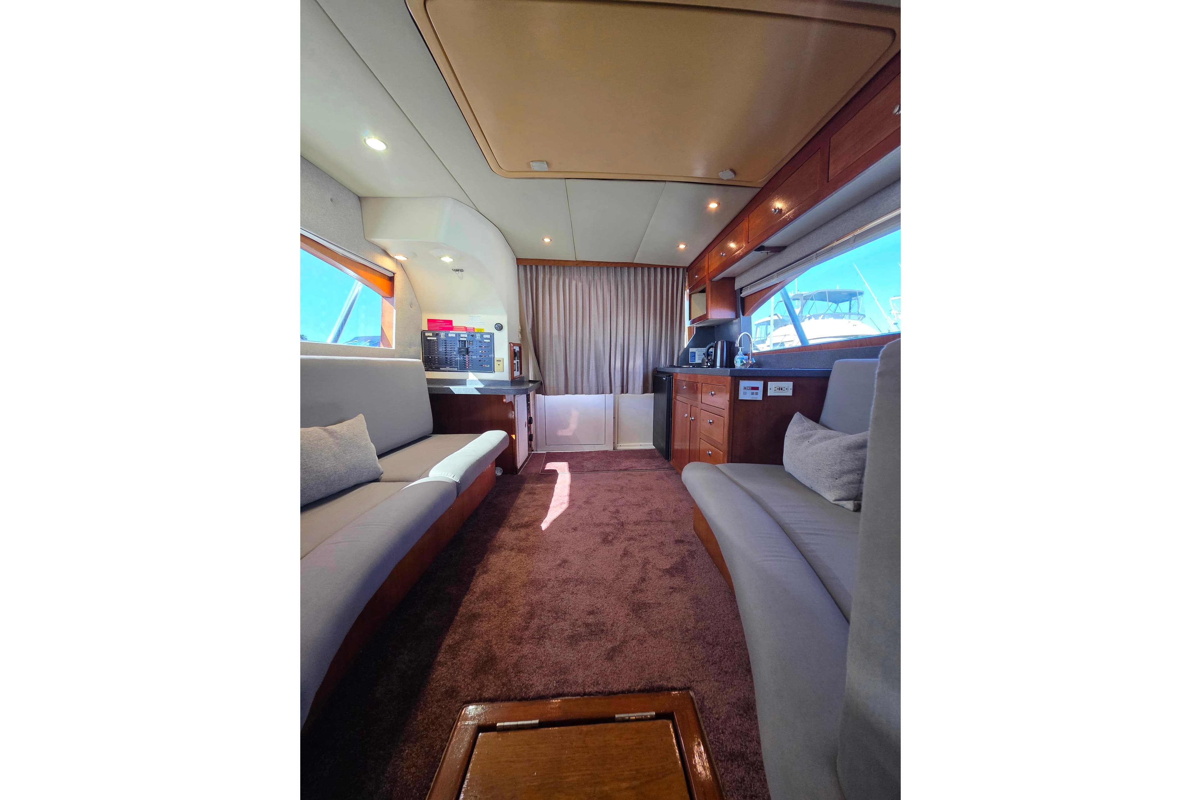 Interior of 2002 Luhrs 34 Convertible yacht with plush seating and wooden cabinetry.