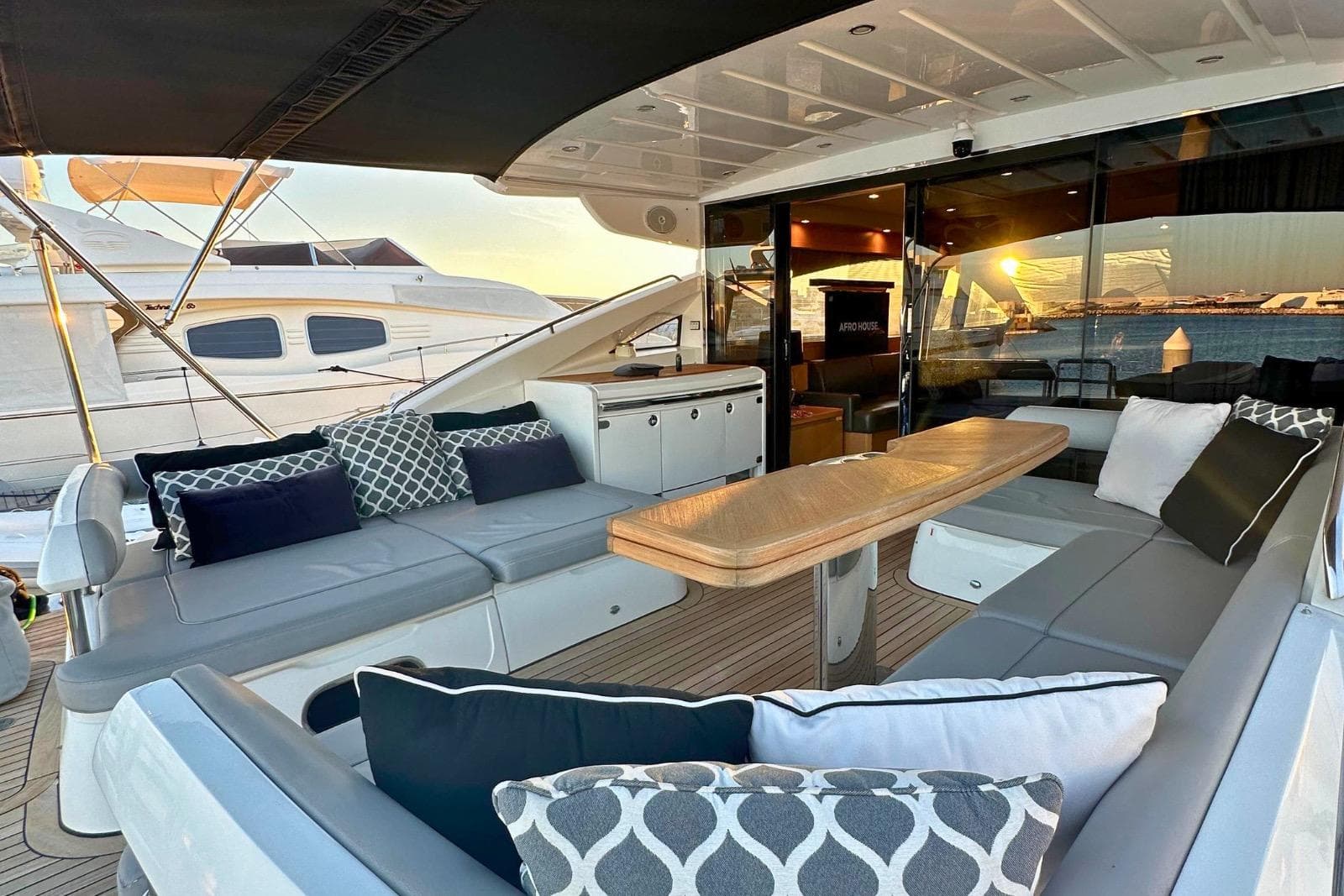 Luxurious 2009 Princess V65 yacht deck with elegant seating and sunset view.