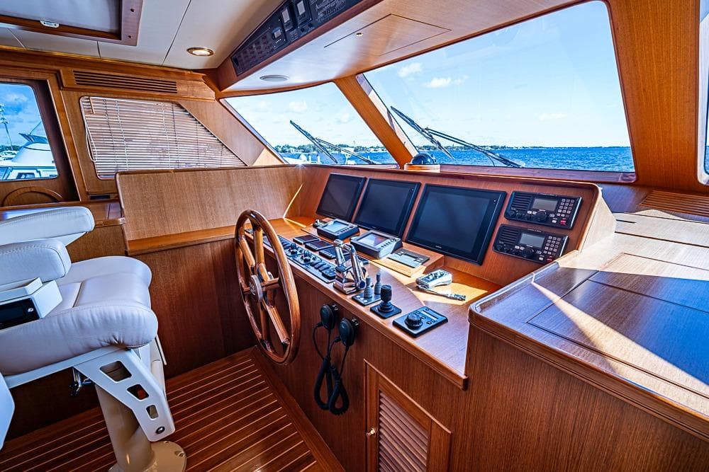 Luxurious 2014 Marlow Explorer 66E yacht helm with wooden finish and advanced navigation systems.