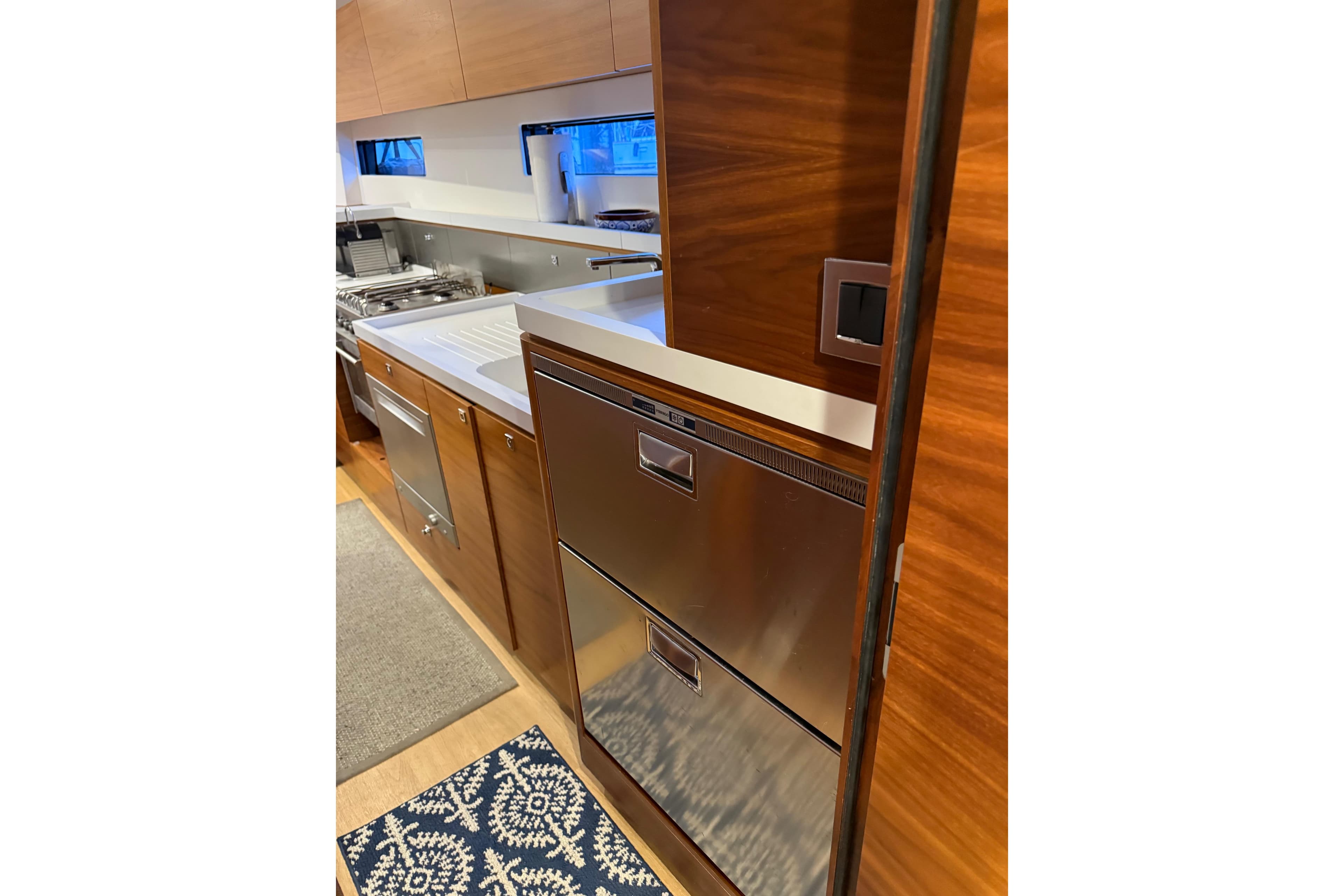 Modern kitchen interior of 2020 Amel 50 yacht with wood cabinetry and stainless steel appliances.