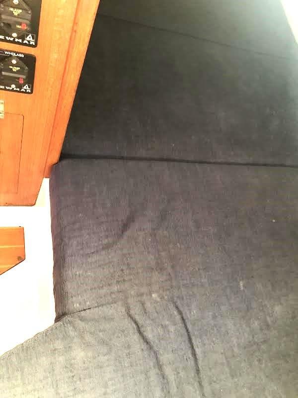 Interior of 1990 Hunter Vision 32 sailboat with dark fabric and wooden paneling.