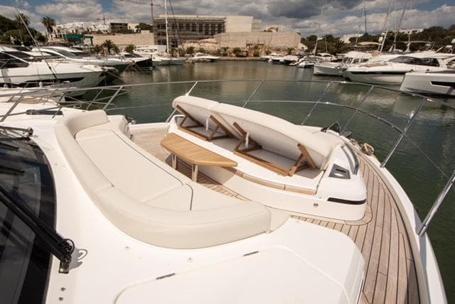 Luxurious 2024 Princess V55 yacht with elegant deck seating in a marina setting.