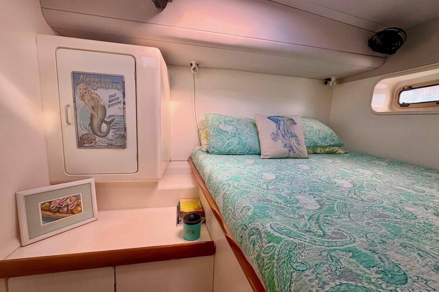 Cozy cabin interior of 2001 Leopard 38 catamaran with nautical decor and patterned bedding.