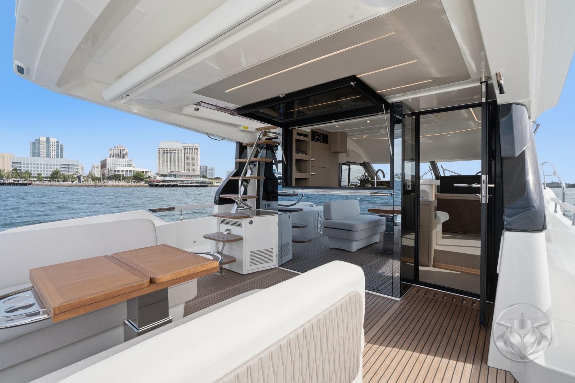 Luxurious Prestige F4.9 yacht interior with modern seating and city skyline view, 2026 model.