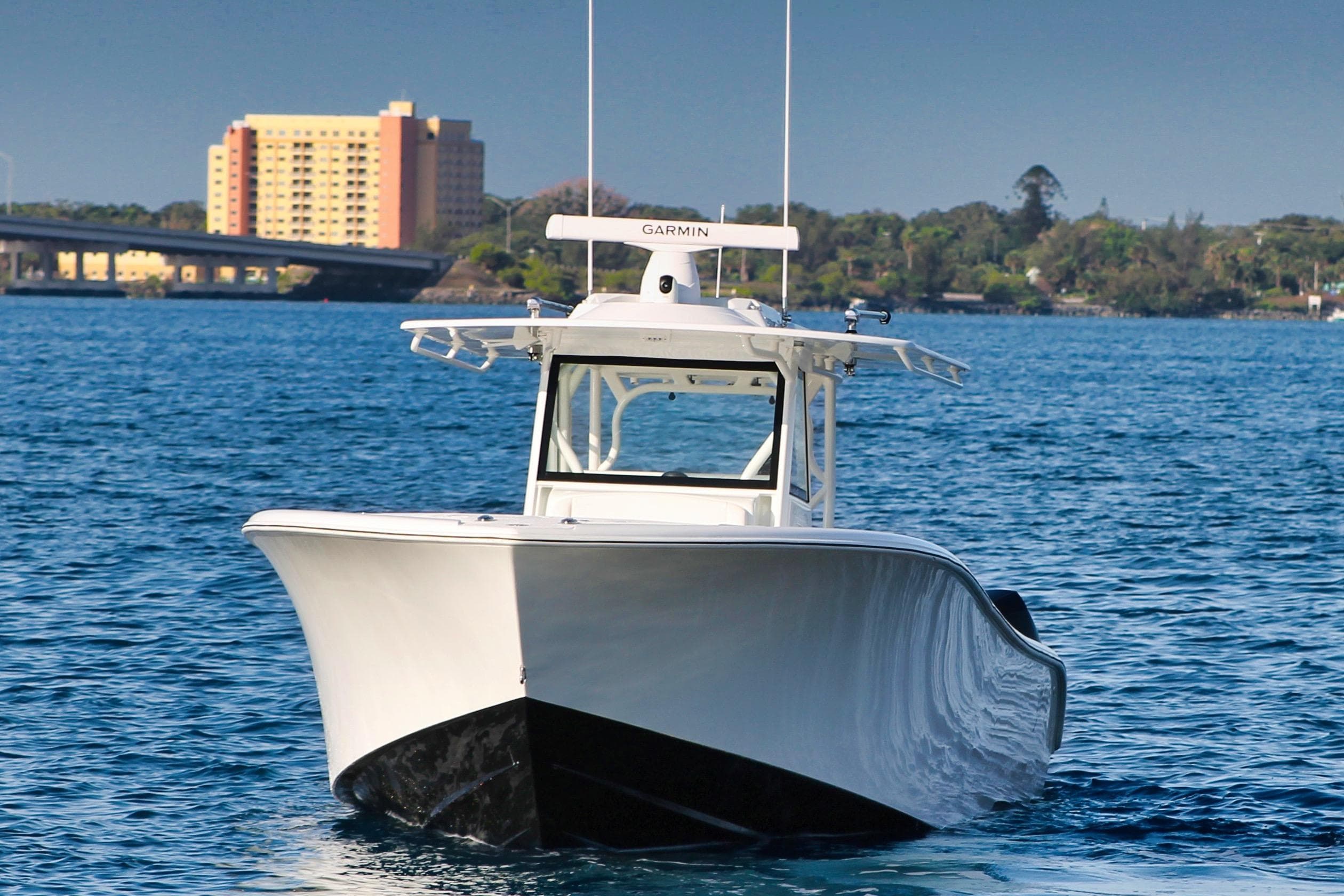 2022 Yellowfin 39 Offshore boat cruising on blue water near a cityscape.
