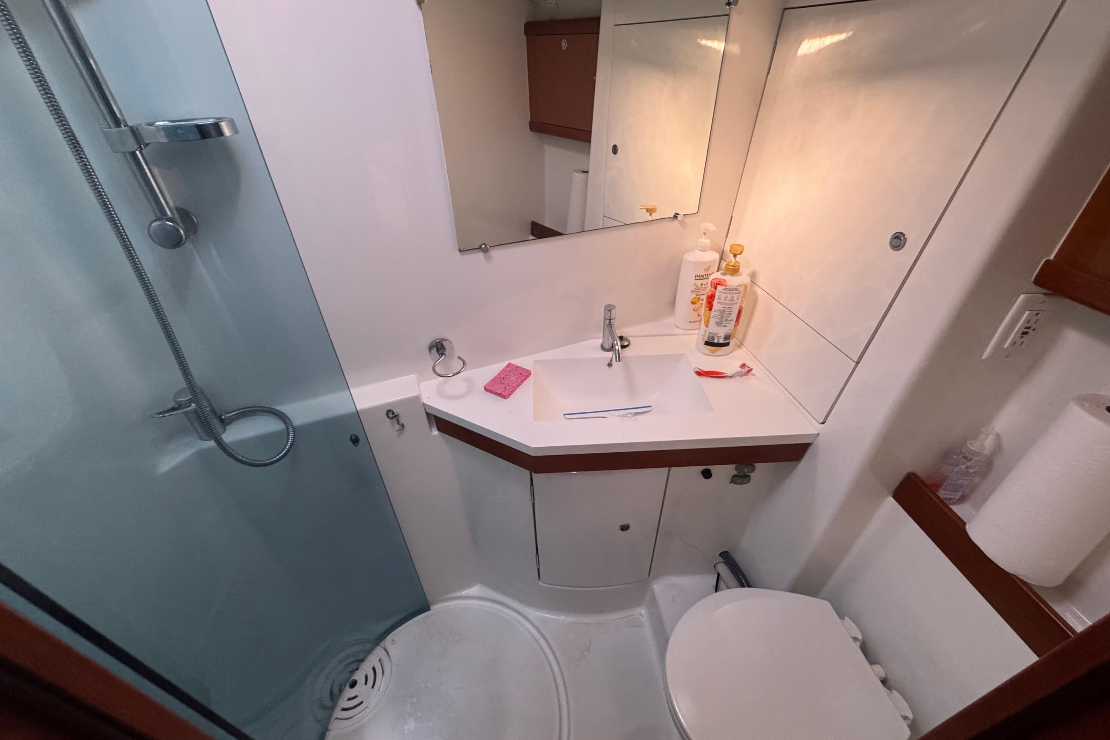 Compact bathroom in a 2009 Benetea 49 yacht, featuring a shower, sink, and toilet.