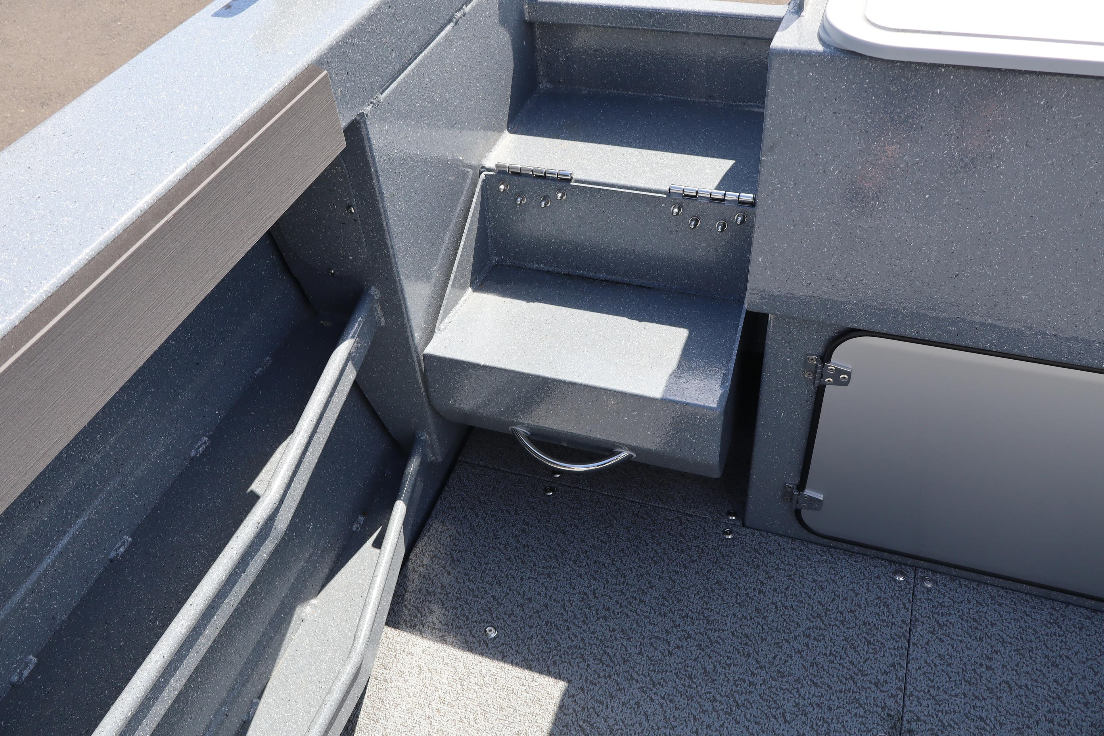 Interior view of 2026 KingFisher 2825 Coastal Express boat, featuring storage compartments and steps.