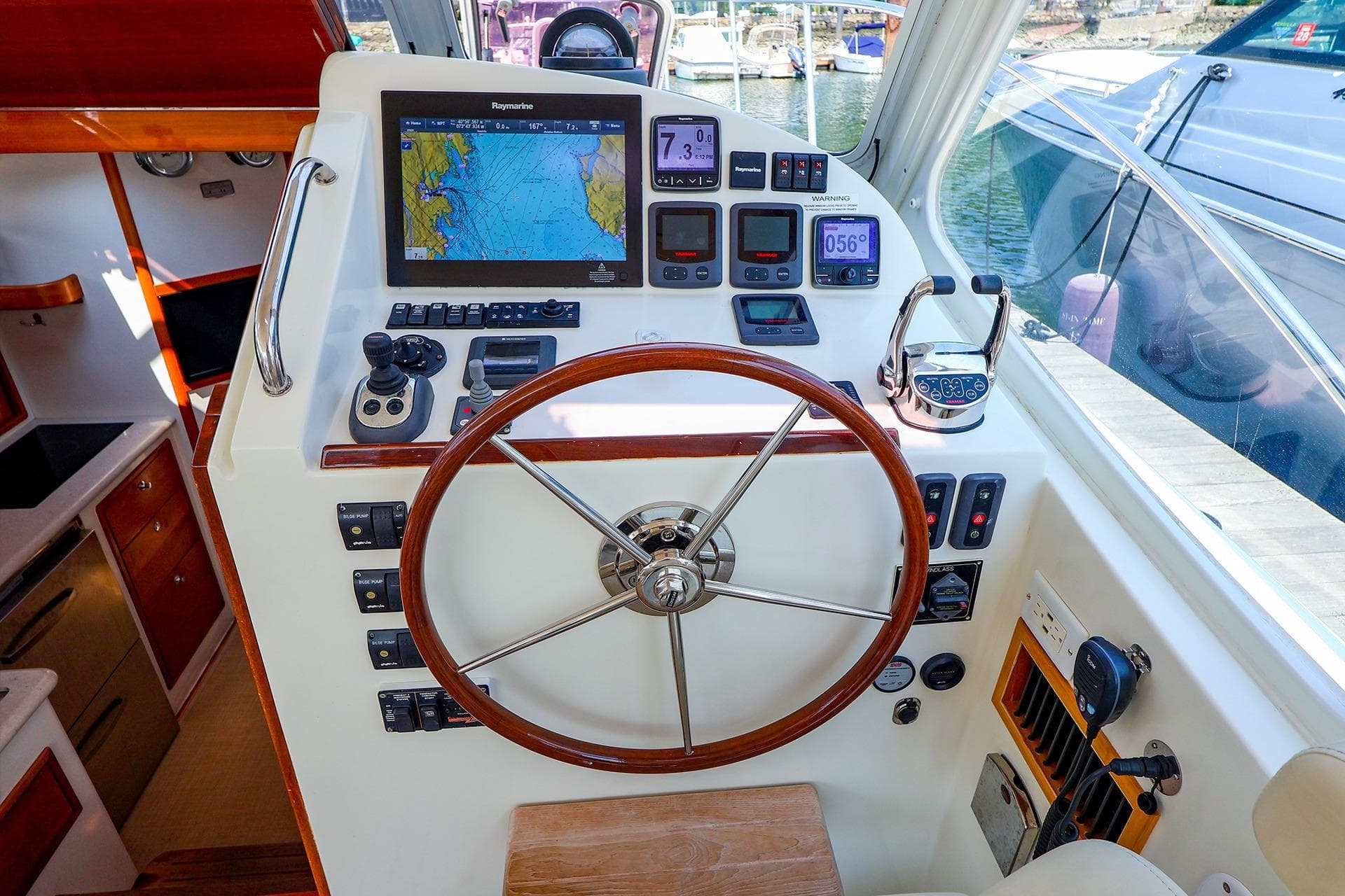 Helm of 2010 MJM 40z Downeast boat with navigation equipment and wooden steering wheel.