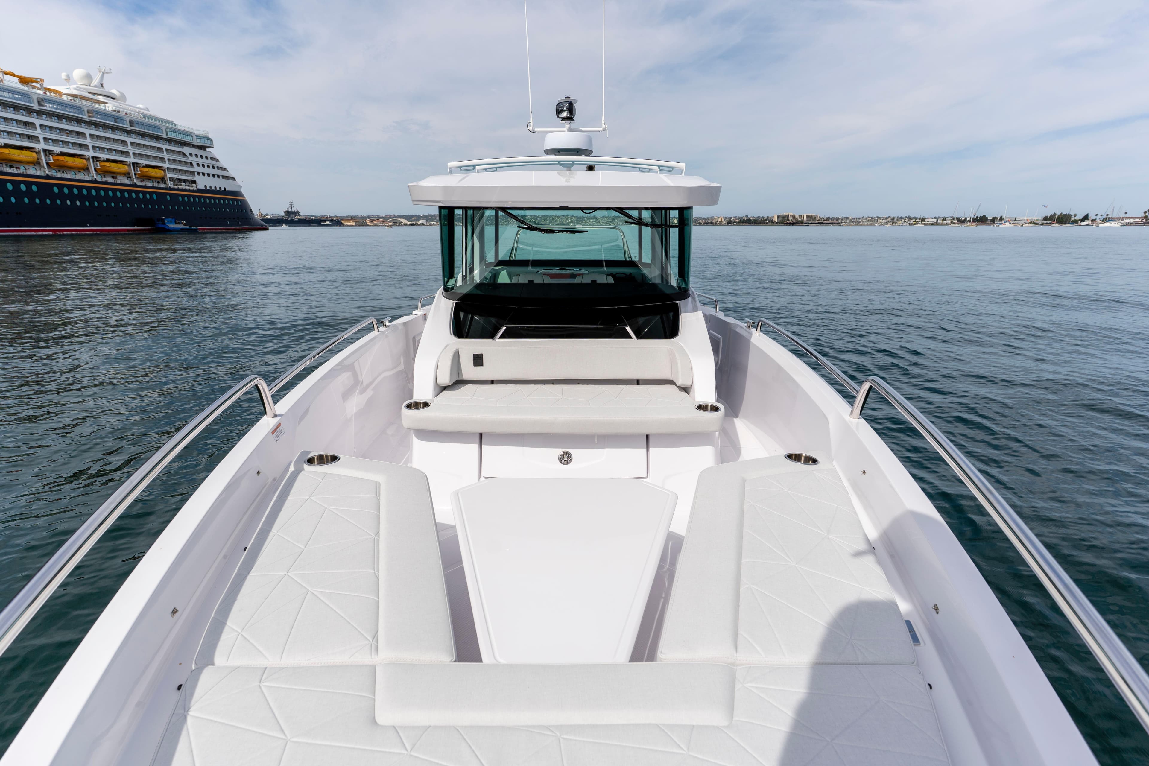 2026 Axopar 29 XC Cross Cabin boat on calm water, with a cruise ship in the background.