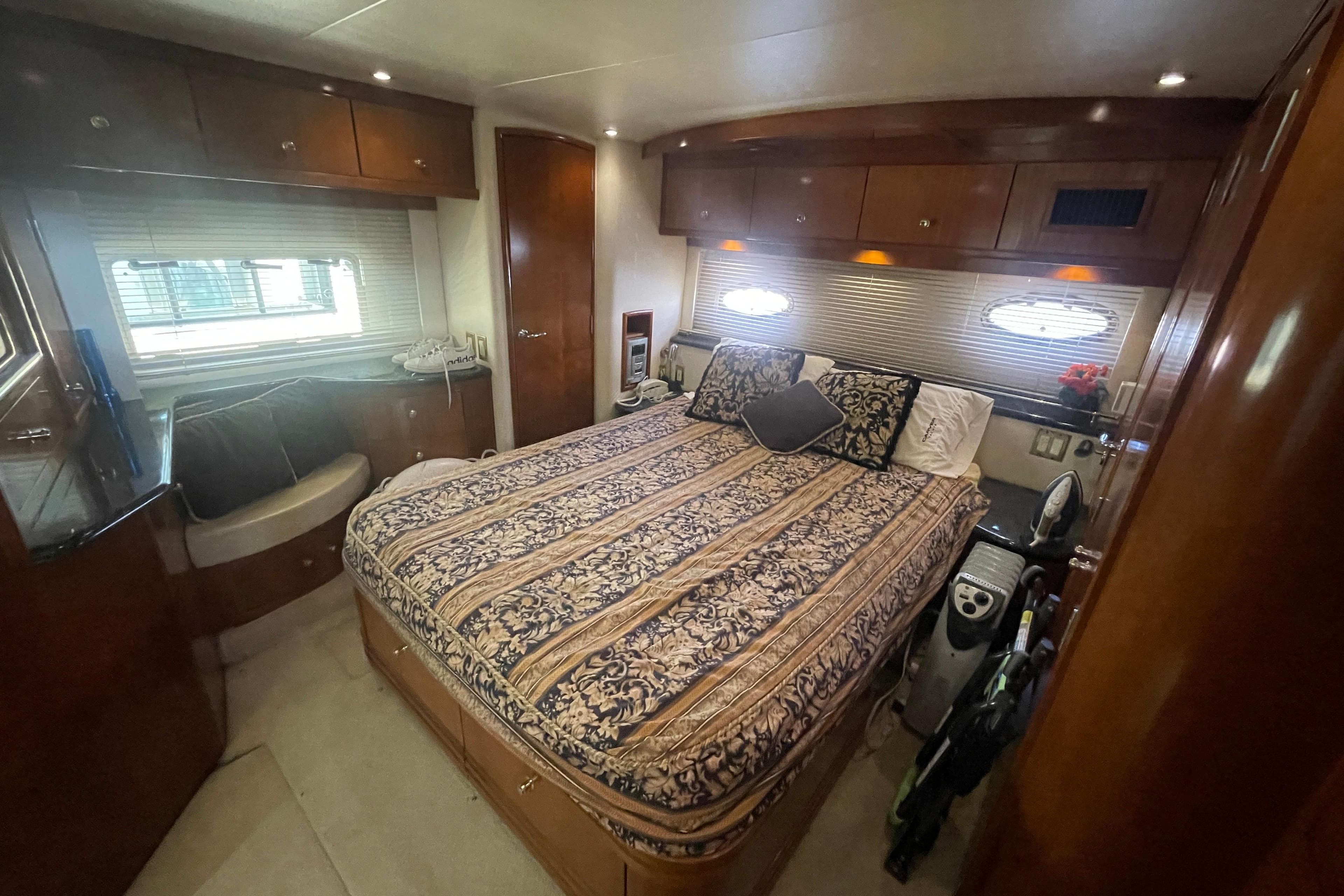 Luxurious bedroom interior of 2000 Carver 506 Motor Yacht with elegant bedding and wood finishes.