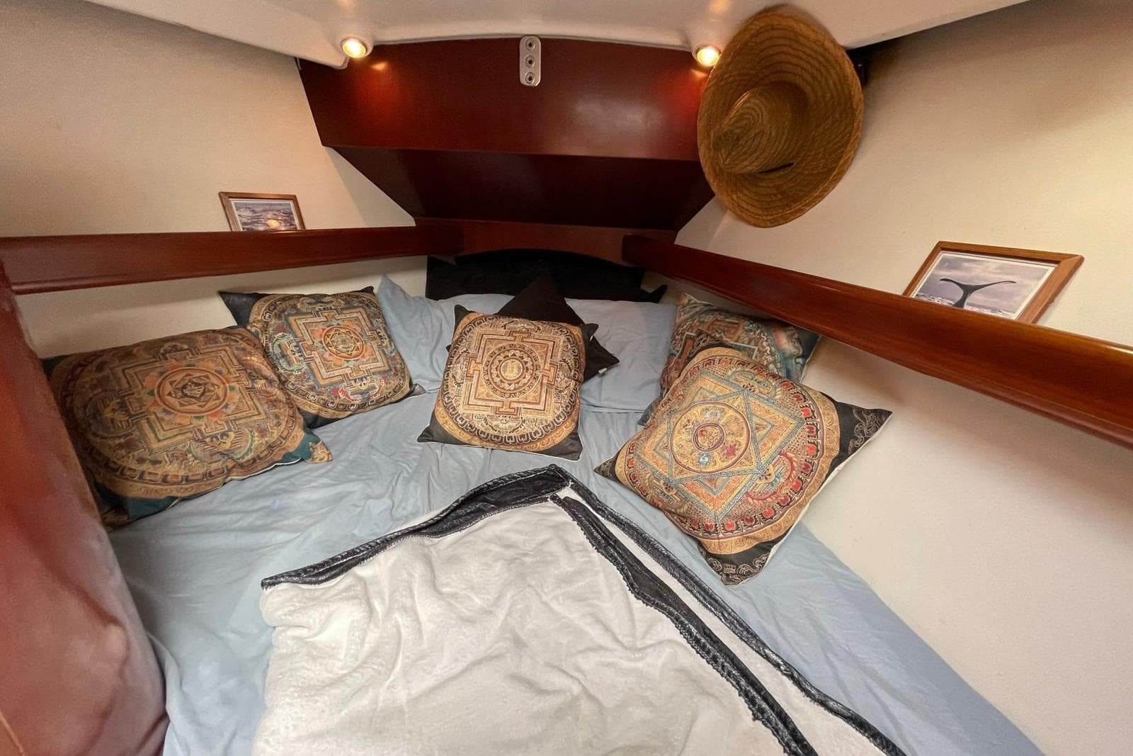 Cozy cabin interior of 2006 Beneteau Oceanis Clipper 523 with decorative pillows and artwork.