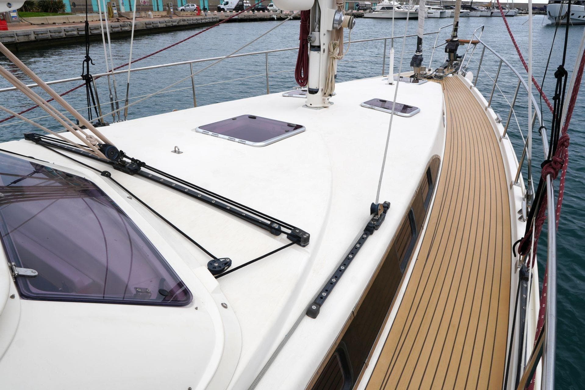 Sailboat deck of 2010 Amel 54, featuring sleek design and wood-like flooring.