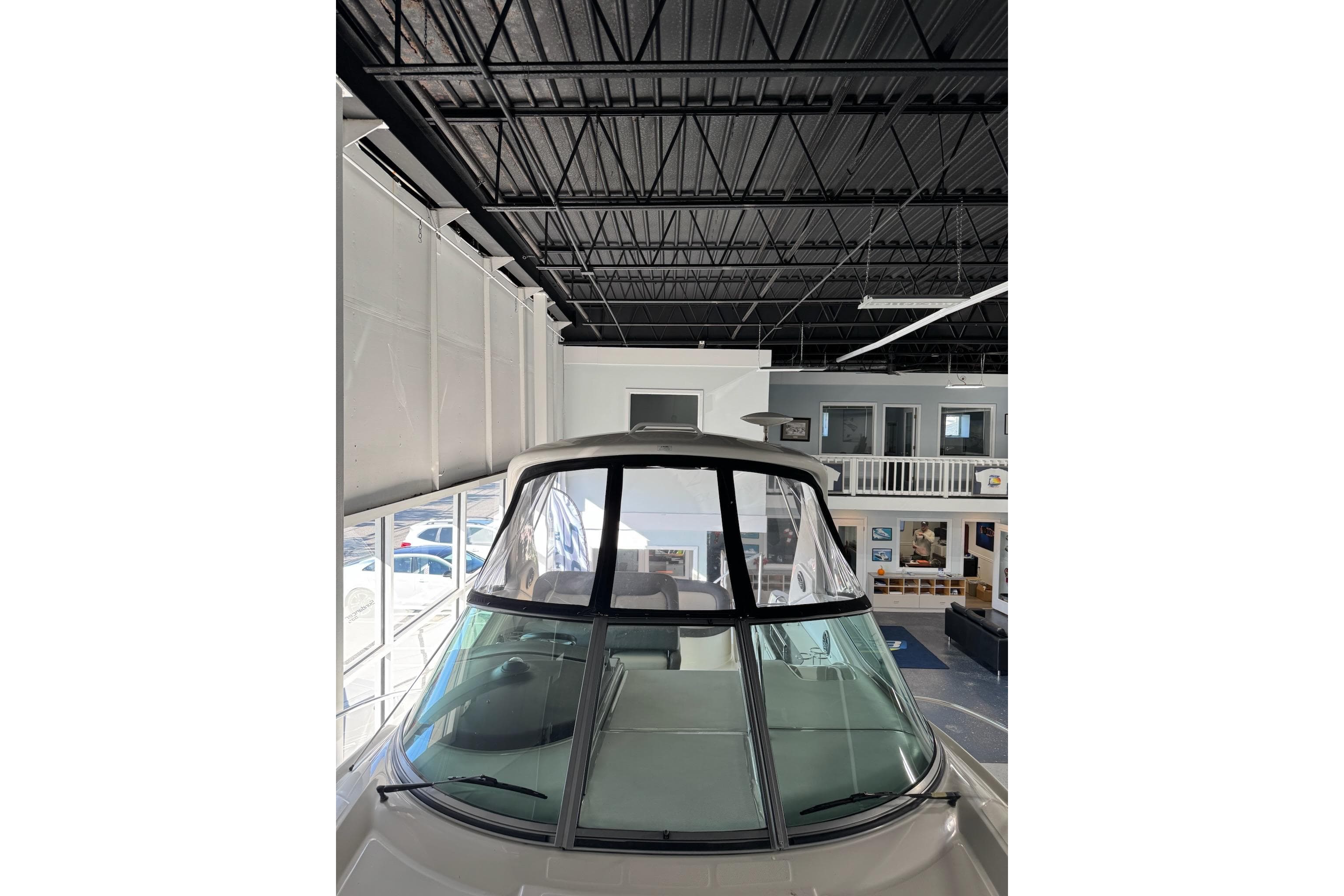 2014 Searay 330 Sundancer boat displayed indoors, showcasing sleek design and spacious cabin.
