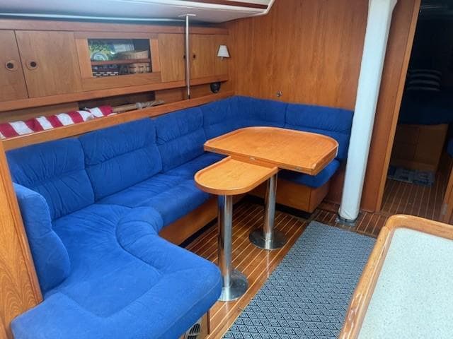 Interior of 2003 Wauquiez Centurion 45s yacht with blue seating and wooden table.