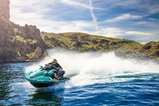 2026 Kawasaki Jetski Ultra 310LX-S speeding on a scenic lake.