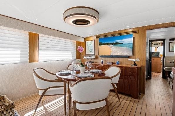 Luxurious interior of 1989 Hatteras 70 Motor Yacht with elegant dining area and modern decor.